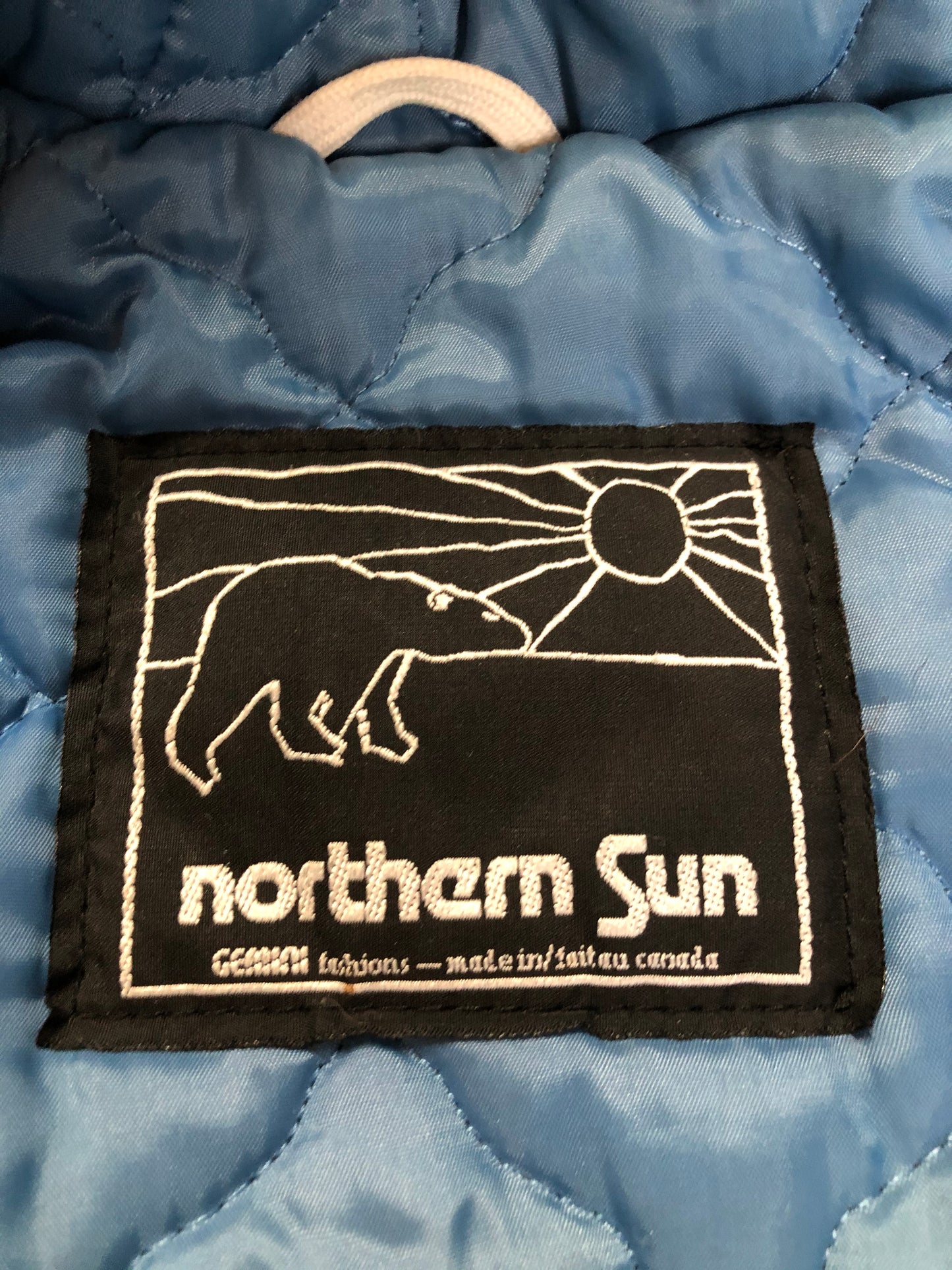 Kingspier Vintage - Northern Sun pure virgin wool northern parka in light blue. This parka features a hood with white fur trim, zipper closure, quilted lining, slash pockets, hidden inside knit cuffs, embroidered polar bear design on the front and back. Made in Canada.