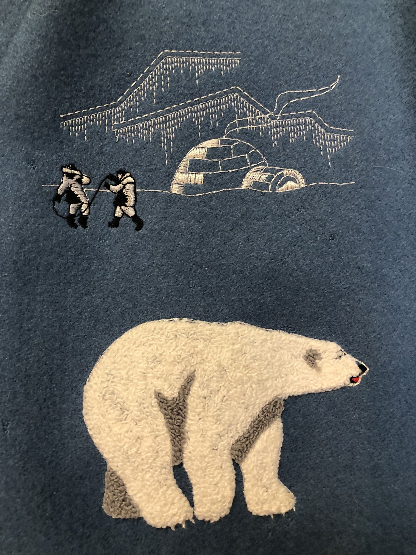 Kingspier Vintage - Northern Sun pure virgin wool northern parka in light blue. This parka features a hood with white fur trim, zipper closure, quilted lining, slash pockets, hidden inside knit cuffs, embroidered polar bear design on the front and back. Made in Canada.