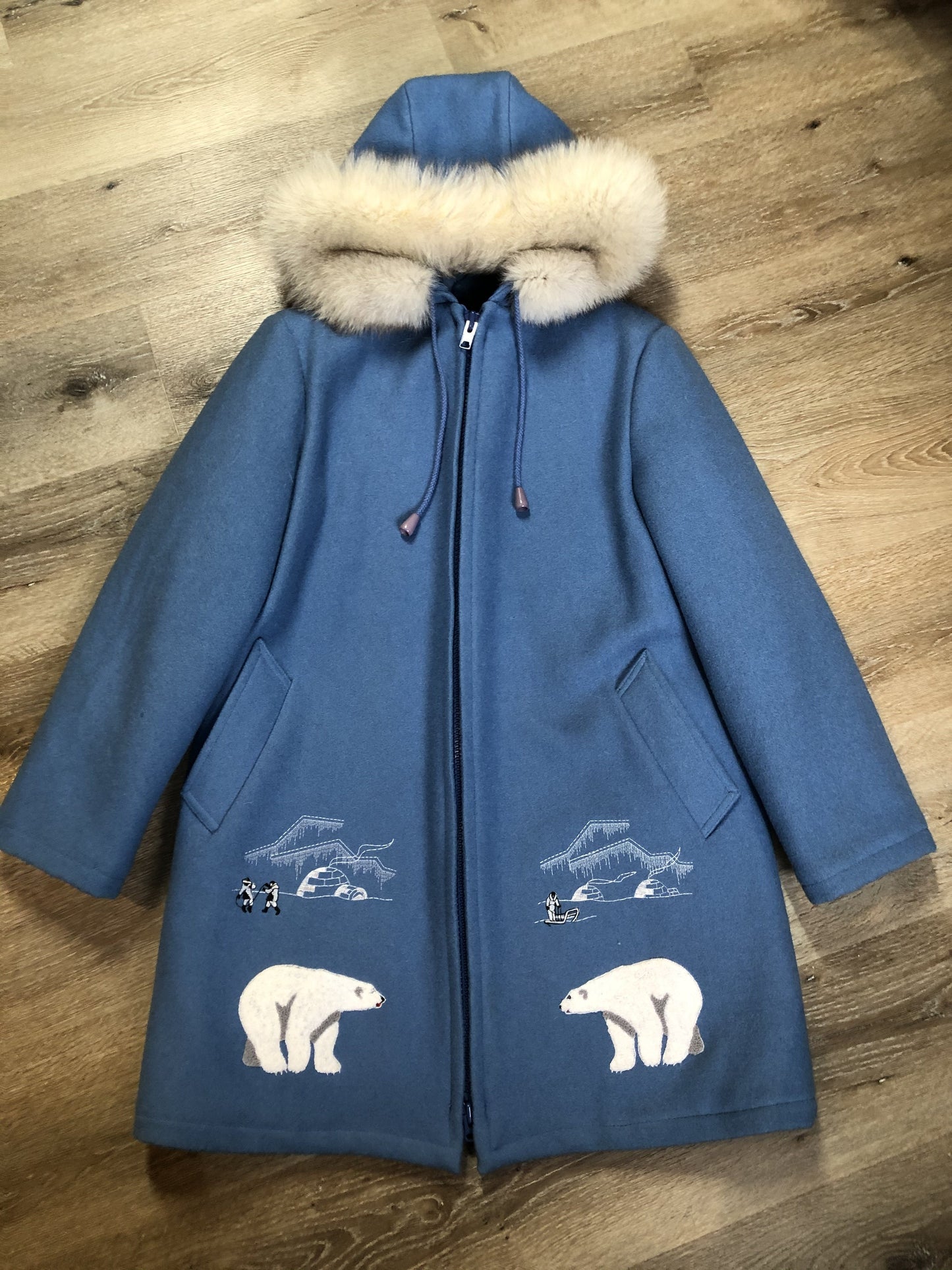Kingspier Vintage - Northern Sun pure virgin wool northern parka in light blue. This parka features a hood with white fur trim, zipper closure, quilted lining, slash pockets, hidden inside knit cuffs, embroidered polar bear design on the front and back. Made in Canada.