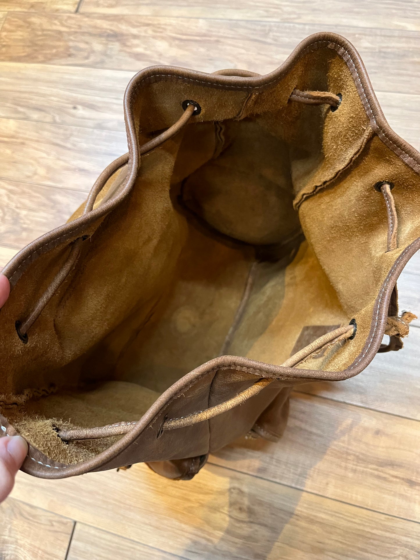 Vintage Roots Tribal Leather brown knapsack with adjustable shoulder straps, drawstring and buckle closures, one large main compartment and three small outer pockets.
Made in Canada