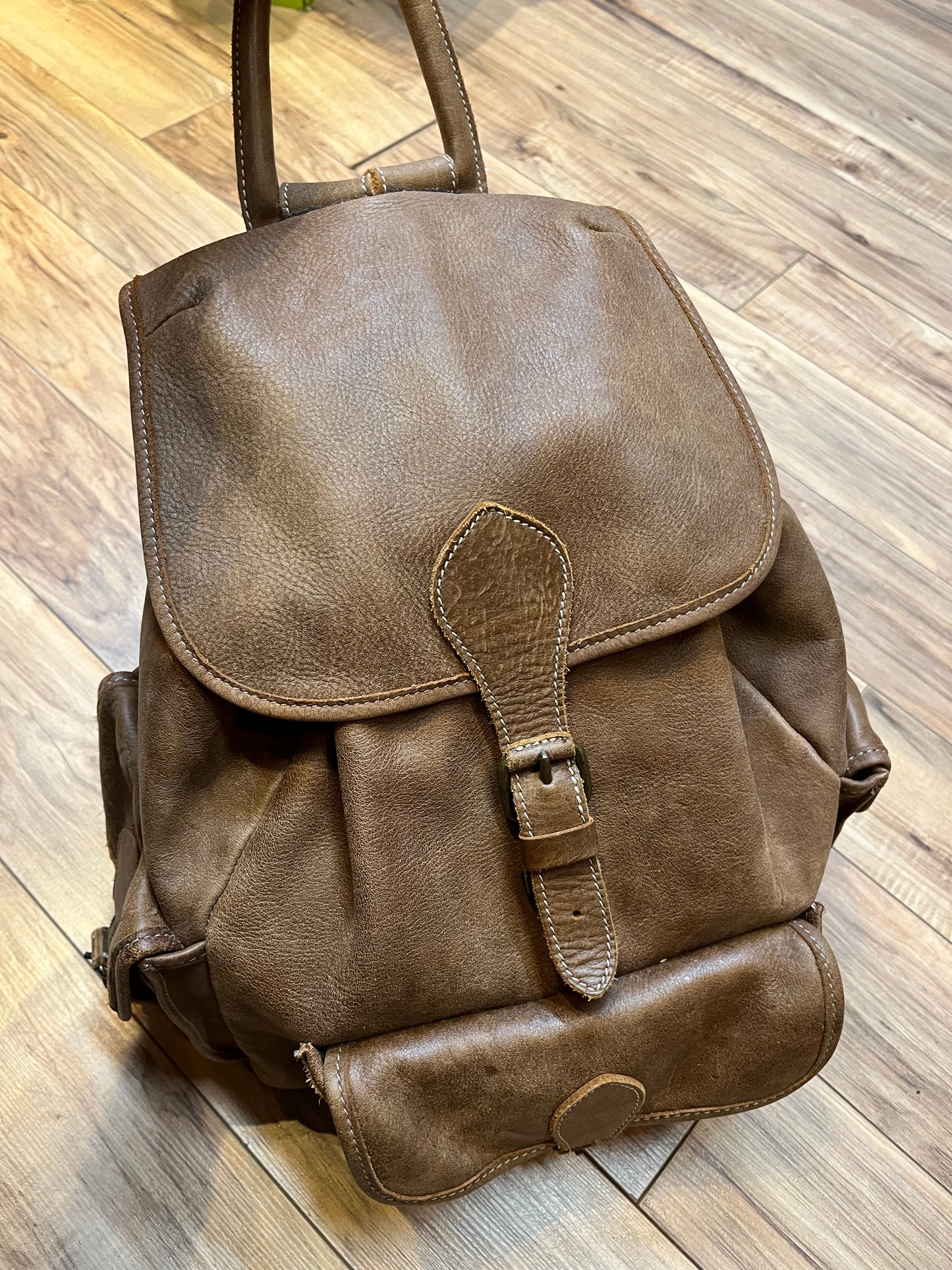 Vintage Roots Tribal Leather brown knapsack with adjustable shoulder straps, drawstring and buckle closures, one large main compartment and three small outer pockets.
Made in Canada