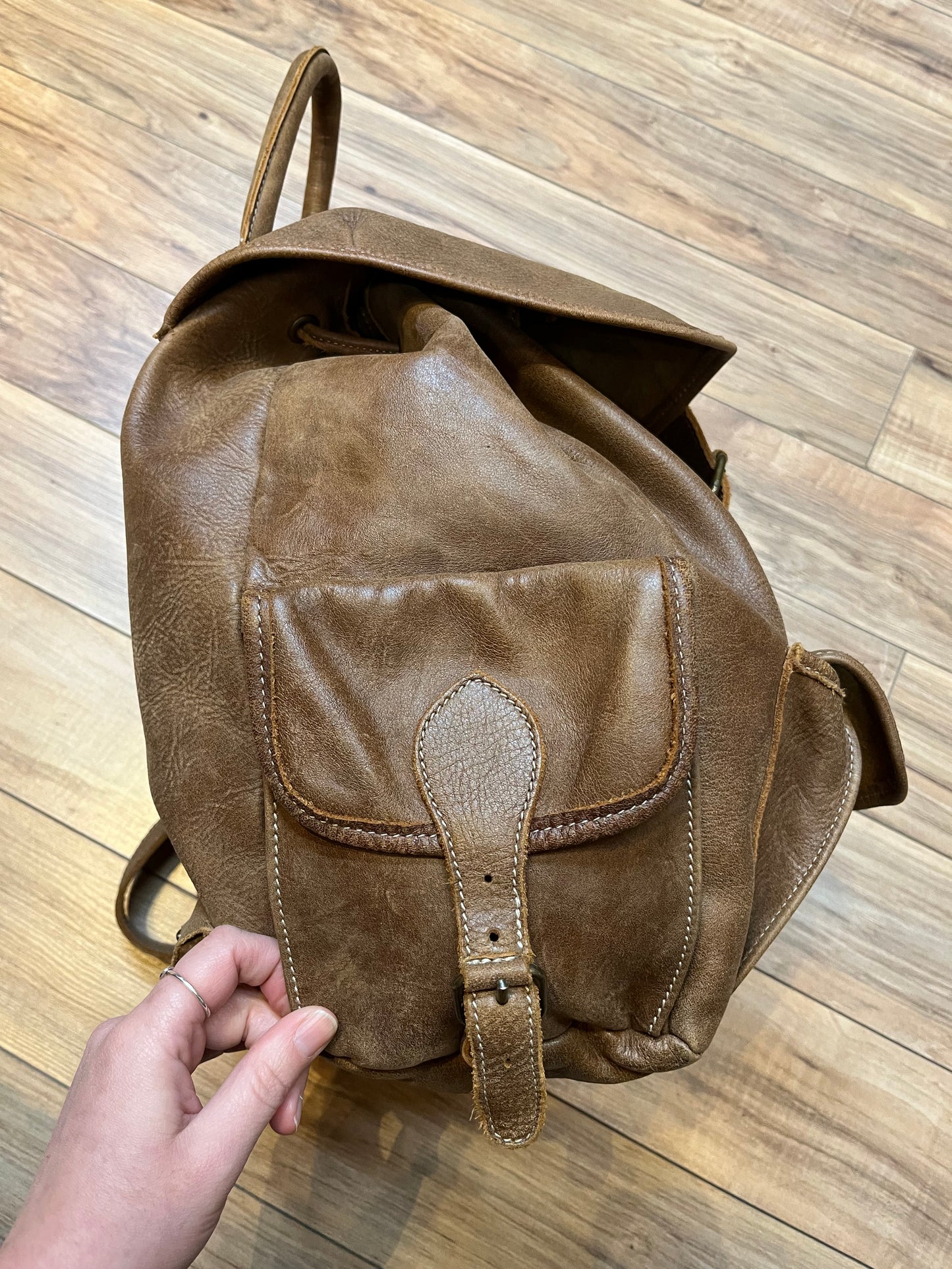 Vintage Roots Tribal Leather brown knapsack with adjustable shoulder straps, drawstring and buckle closures, one large main compartment and three small outer pockets.
Made in Canada