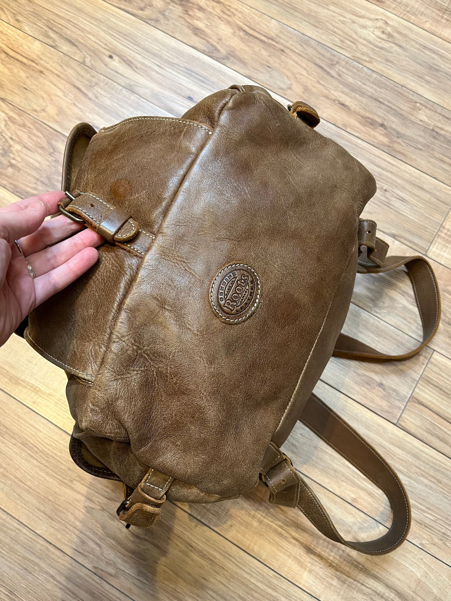 Vintage Roots Tribal Leather brown knapsack with adjustable shoulder straps, drawstring and buckle closures, one large main compartment and three small outer pockets.
Made in Canada
