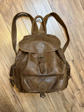 Load image into Gallery viewer, Vintage Roots Tribal Leather brown knapsack with adjustable shoulder straps, drawstring and buckle closures, one large main compartment and three small outer pockets.

Made in Canada
