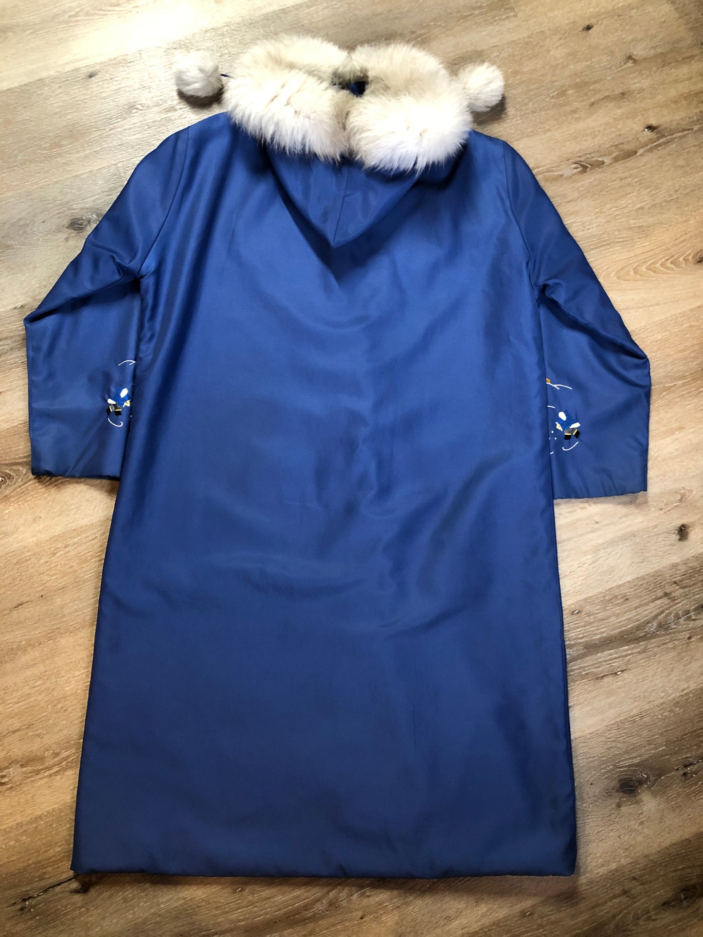 Kingspier Vintage - Blue northern parka made by Marilyn Bessey with wool blend lining, hood with white fur trim, fur Pom poms, zipper closure, patch pockets, arctic life design embroidered on the front pockets and the sleeves. Made in Canada.