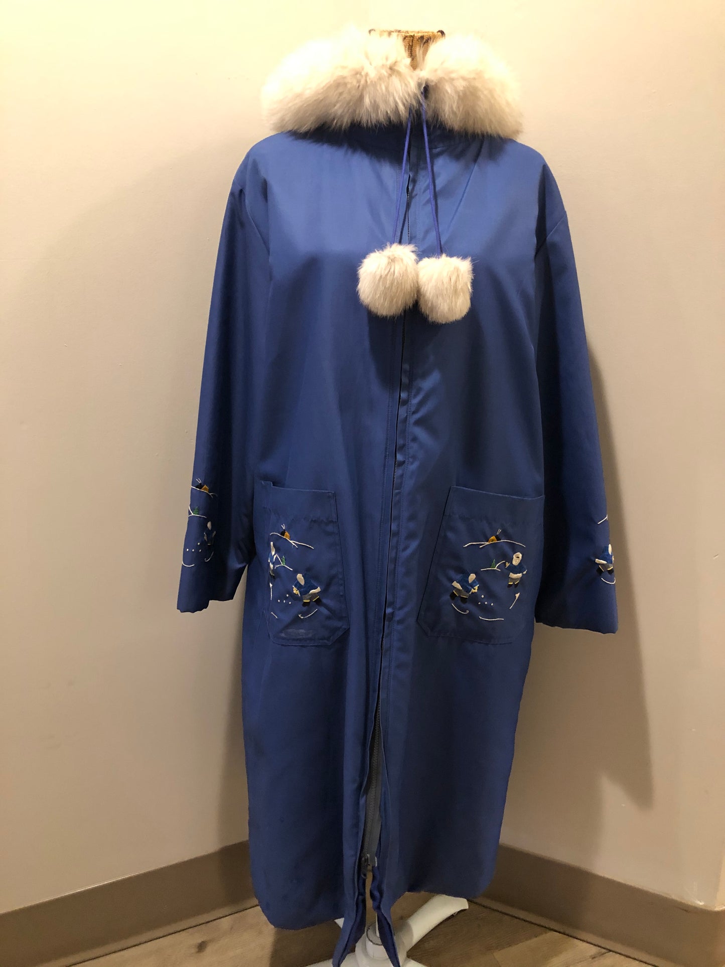 Kingspier Vintage - Blue northern parka made by Marilyn Bessey with wool blend lining, hood with white fur trim, fur Pom poms, zipper closure, patch pockets, arctic life design embroidered on the front pockets and the sleeves. Made in Canada.