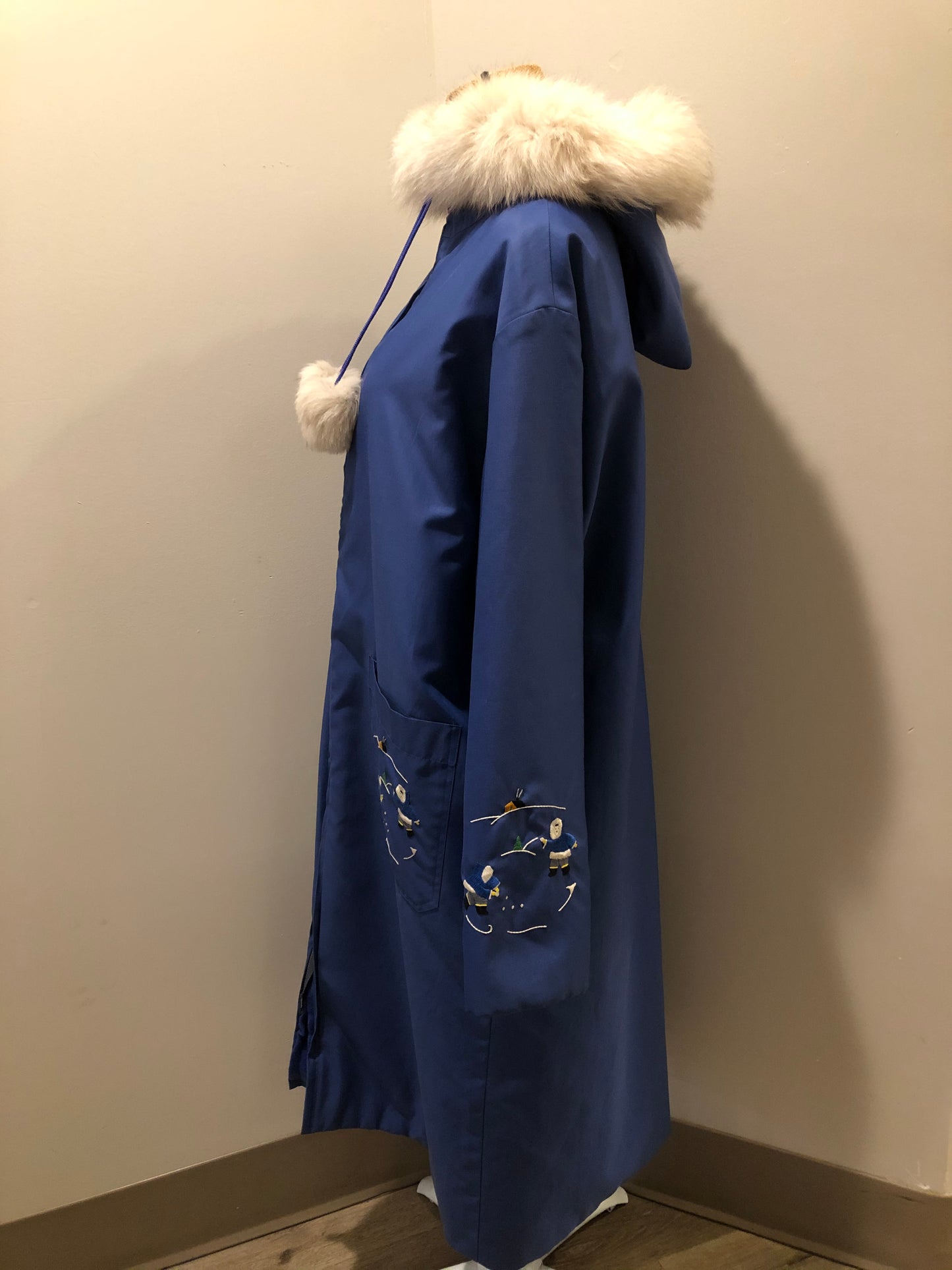 Kingspier Vintage - Blue northern parka made by Marilyn Bessey with wool blend lining, hood with white fur trim, fur Pom poms, zipper closure, patch pockets, arctic life design embroidered on the front pockets and the sleeves. Made in Canada.