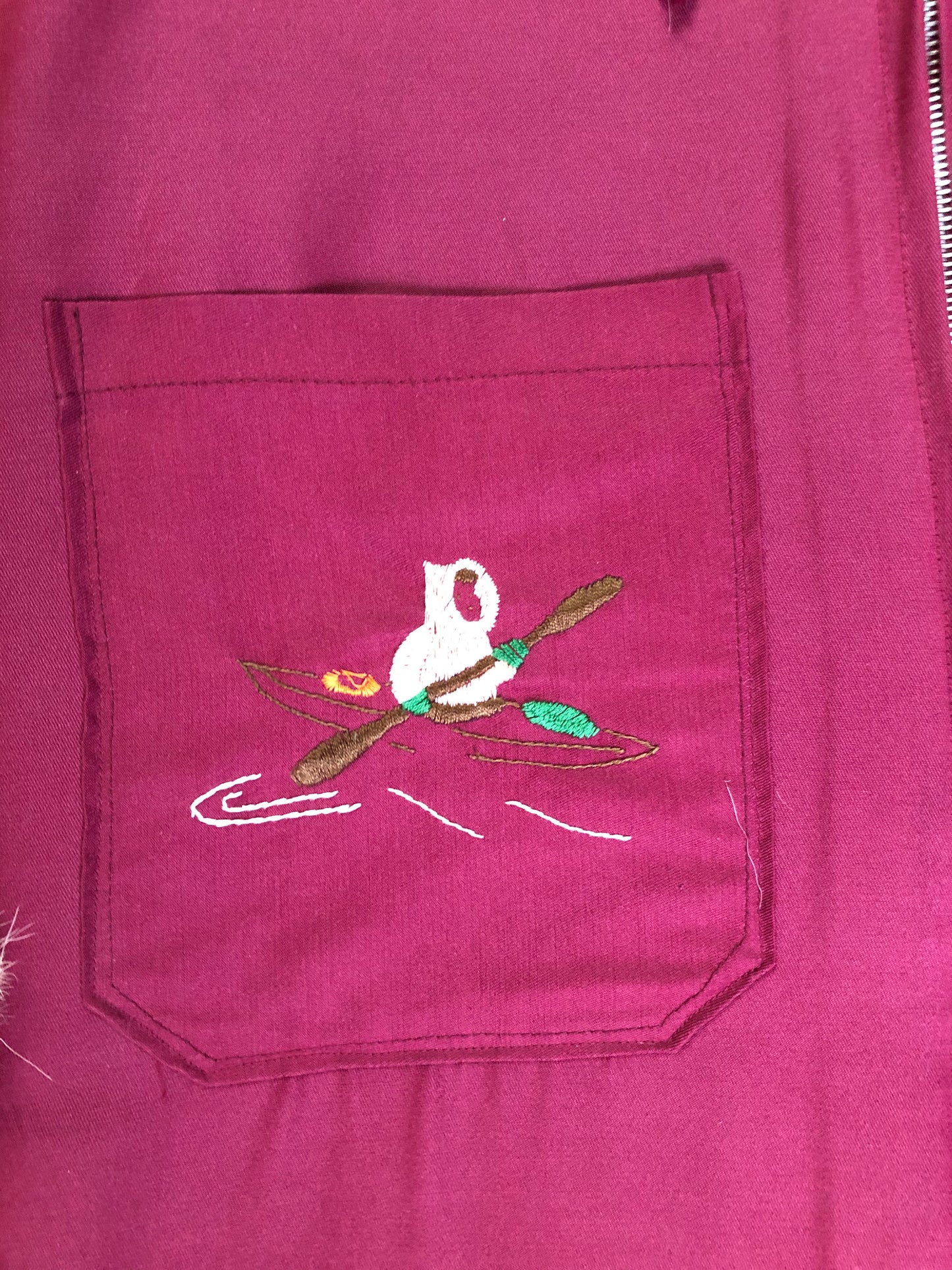 Kingspier Vintage - Pink Northern parka with wool blend lining, hood and sleeves with white fur trim, fur Pom poms, zipper closure, patch pockets, canoe design embroidered on the front pockets. Made in Canada.