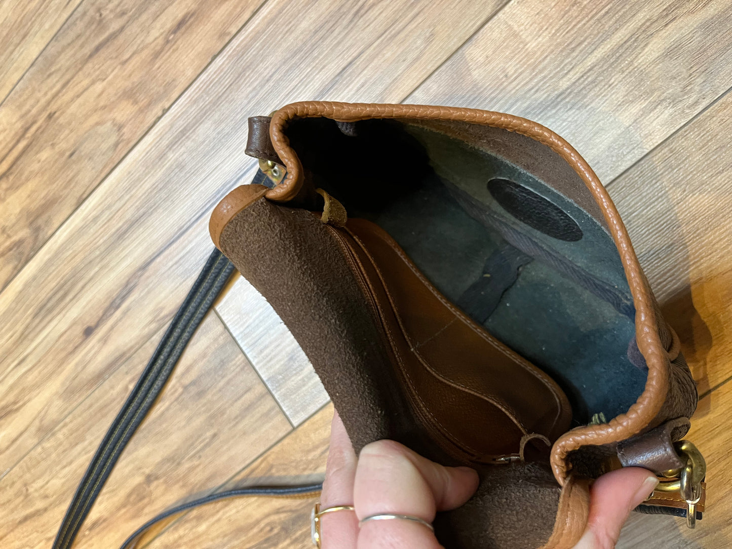 Dooney and Burke small navy and brown pebble leather crossbody bag with multiple pockets and brass hardware.