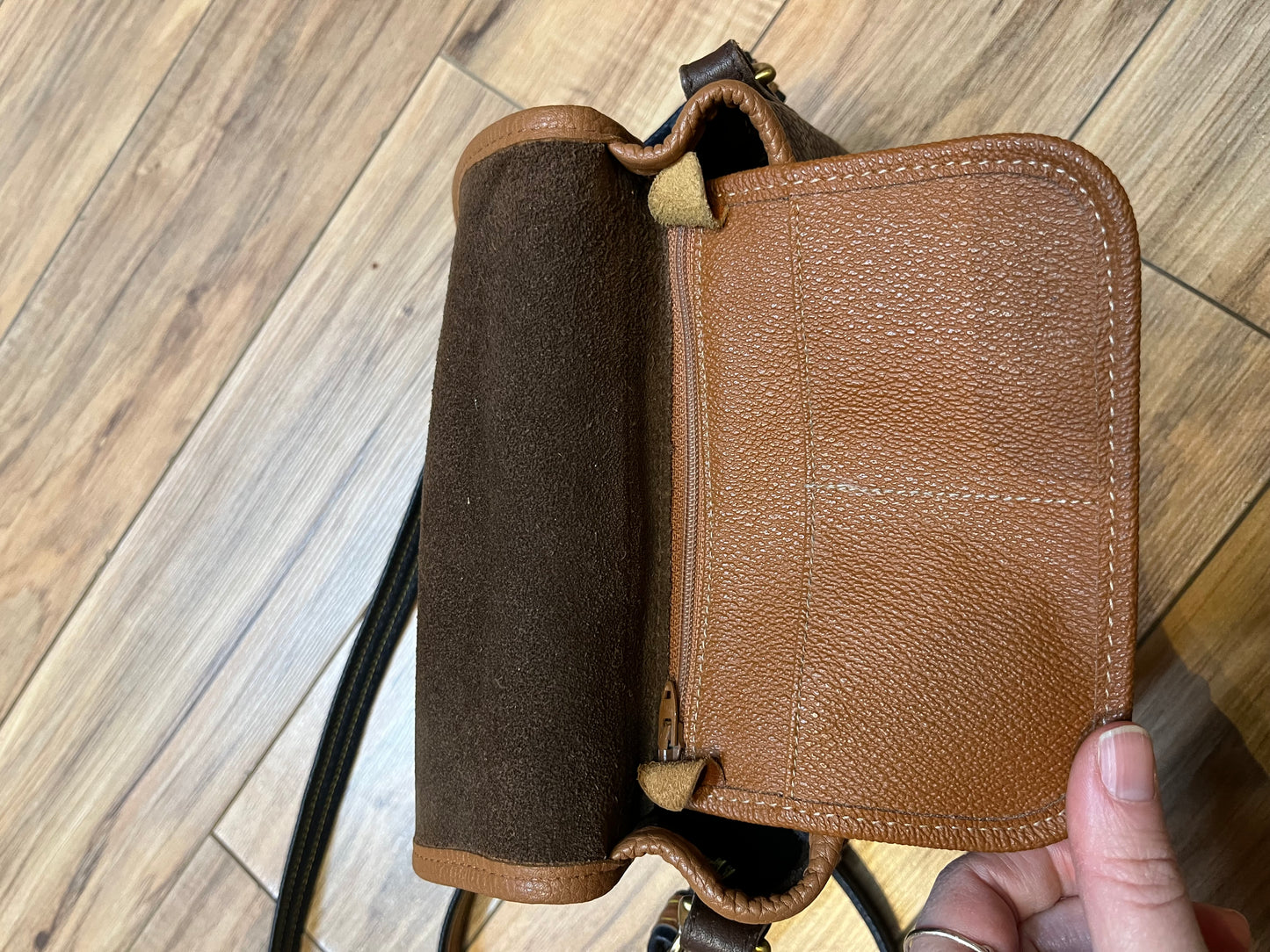 Dooney and Burke small navy and brown pebble leather crossbody bag with multiple pockets and brass hardware.