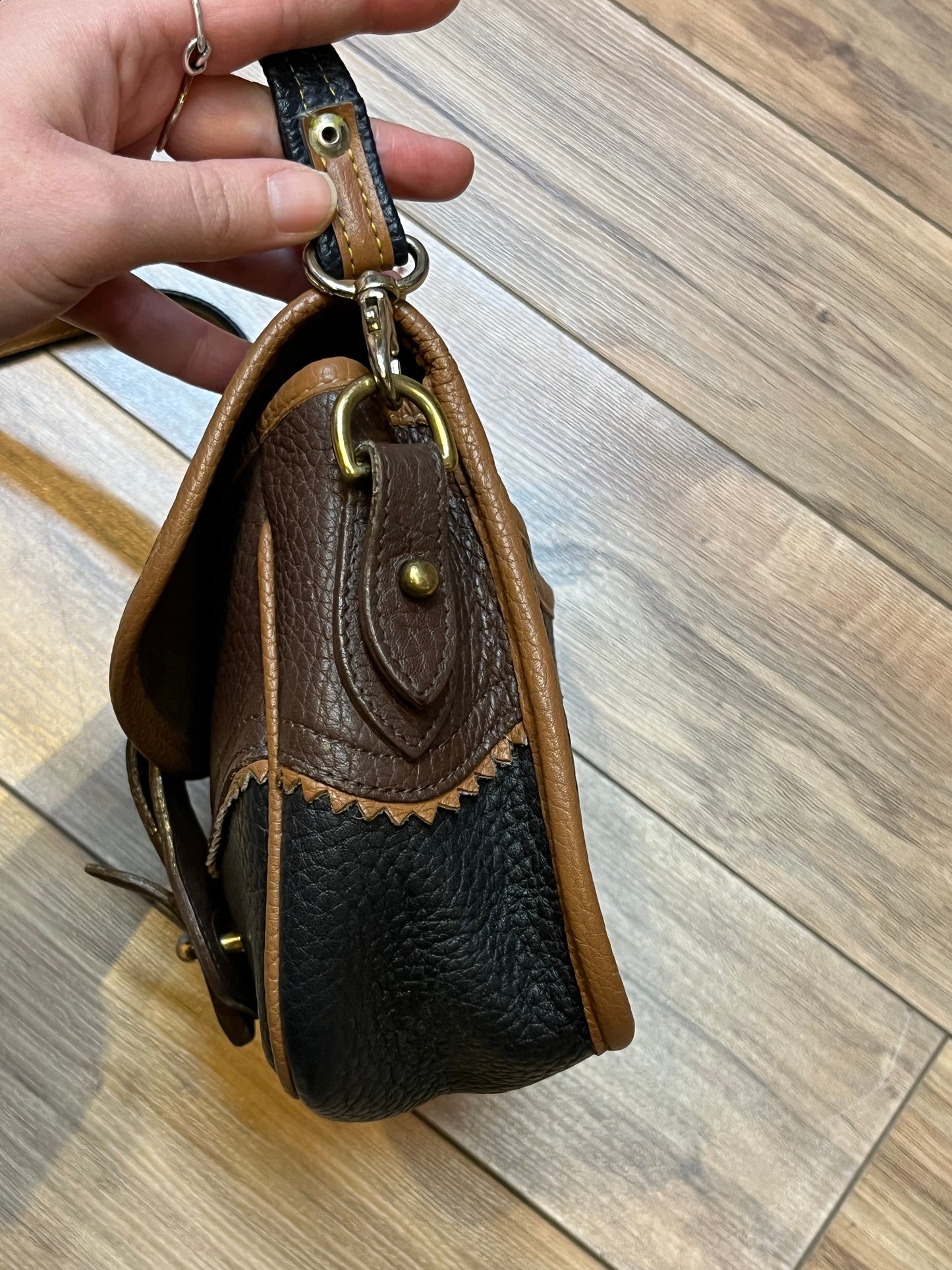 Dooney and Burke small navy and brown pebble leather crossbody bag with multiple pockets and brass hardware.