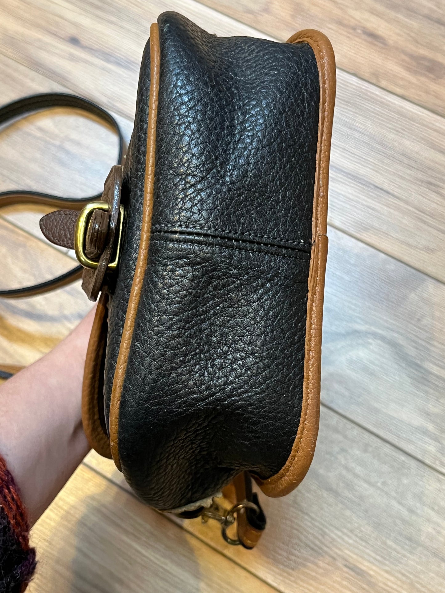 Dooney and Burke small navy and brown pebble leather crossbody bag with multiple pockets and brass hardware.