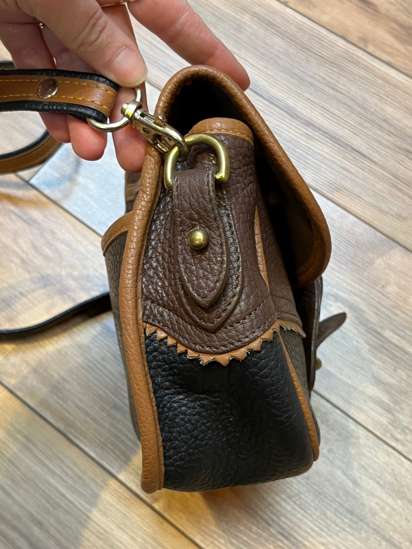 Dooney and Burke small navy and brown pebble leather crossbody bag with multiple pockets and brass hardware.