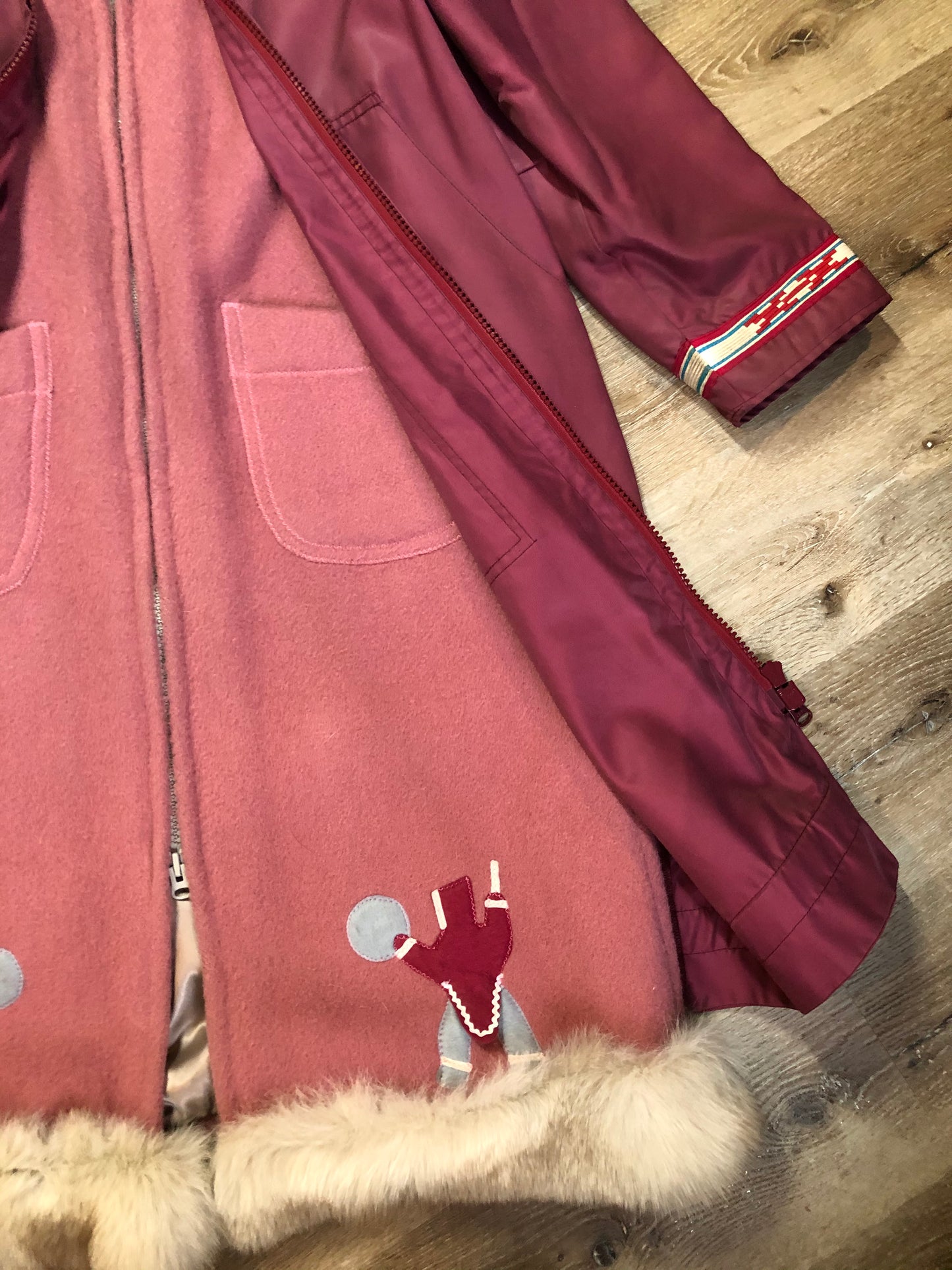 Kingspier Vintage - “Styles North” pink northern parka with removable outer shell featuring a hood with white fur trim, zipper closure, lining, patch pockets, felt warrior appliqué design on the front and back. Made in Canada.
