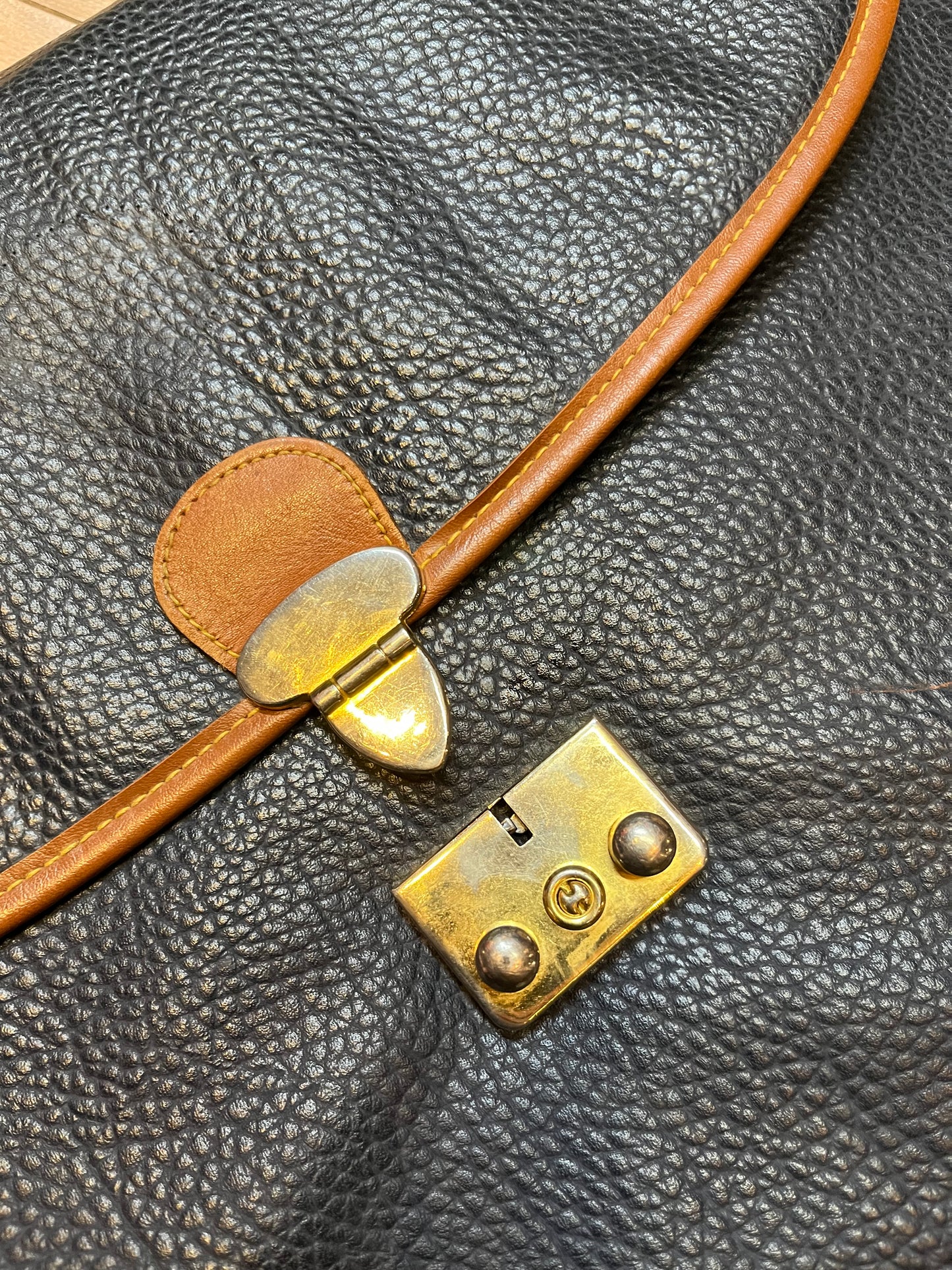Dooney and Burke all weather leather briefcase in navy with top handle, shoulder strap and brass hardware.