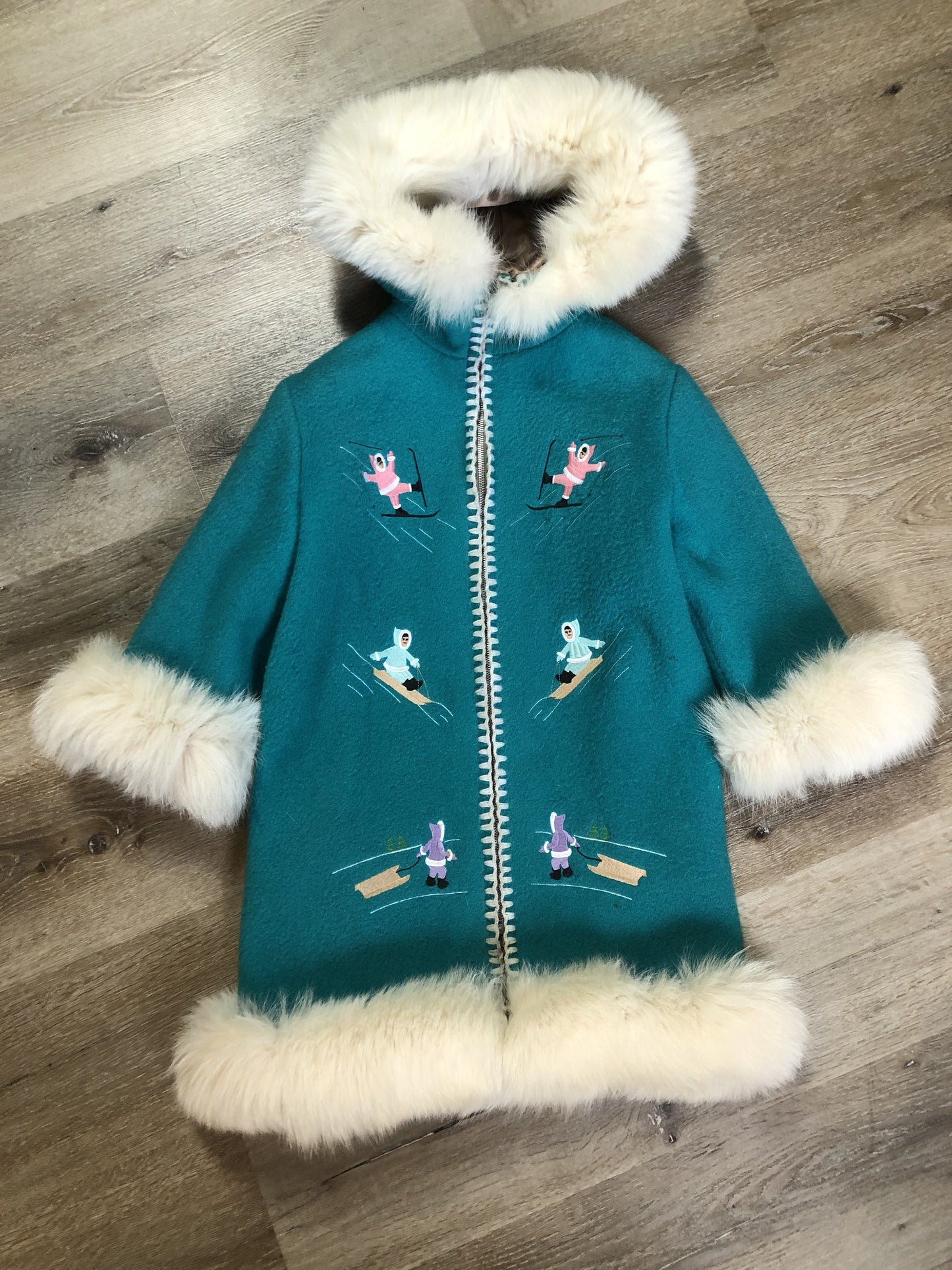 Kingspier Vintage - Children’s Turquoise Wool Humber Handcrafts northern parka featuring a hood, white fur trim, zipper closure, lining, embroidered winter scenes along the front. Made in Canada.