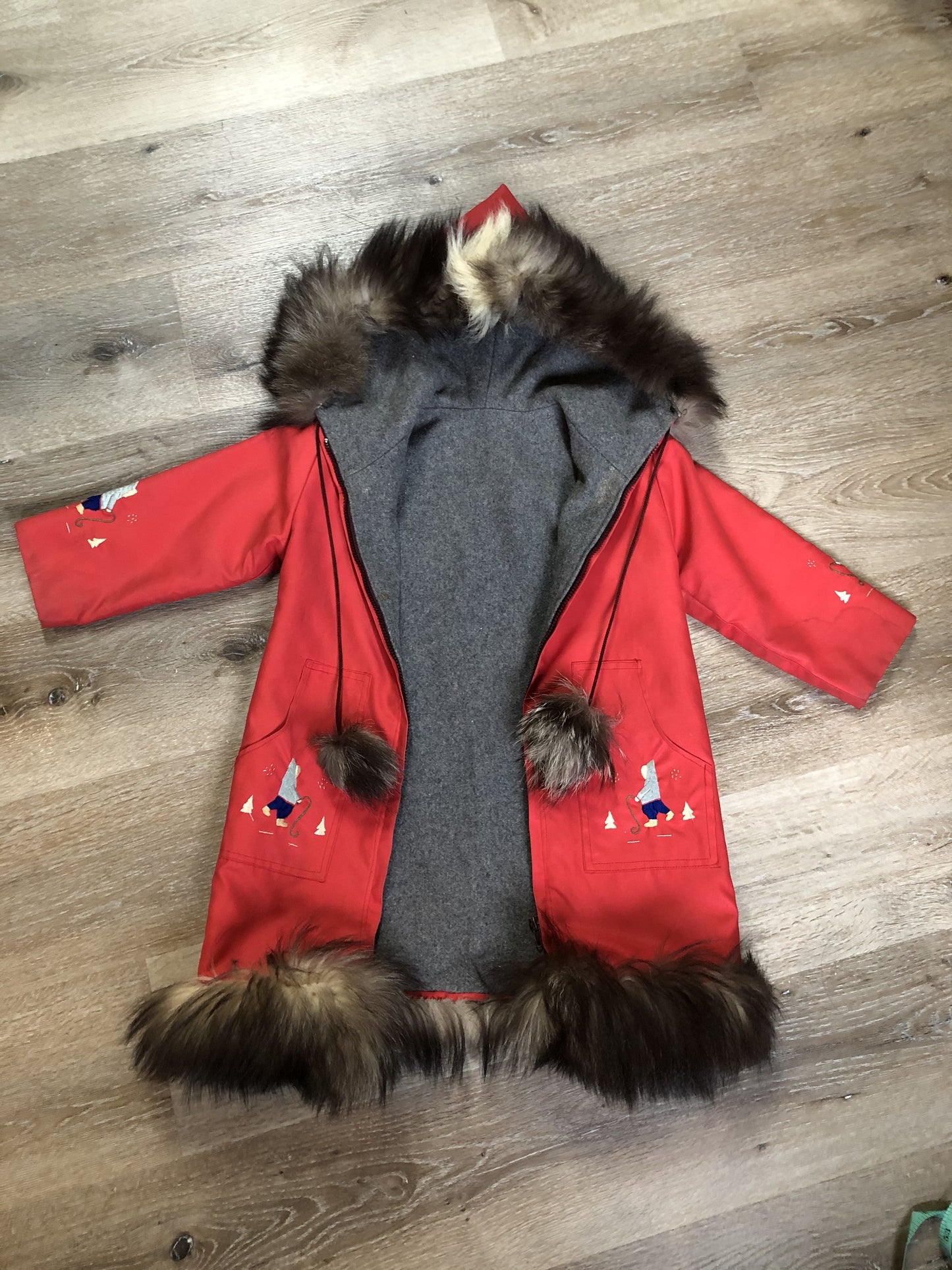 Kingspier Vintage - Children’s red northern parka featuring a hood, fur trim and pom poms, zipper closure, wool lining, patch pockets, embroidered winter scenes along the front. Made in Canada.