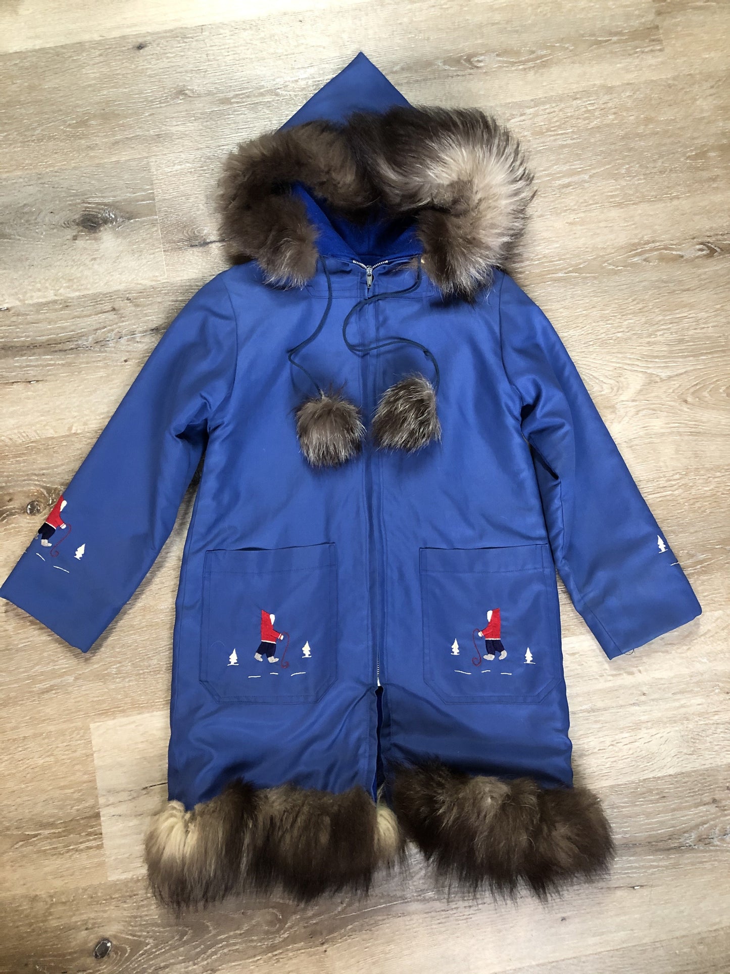 Kingspier Vintage - Children’s blue northern parka featuring a hood, fur trim and pom poms, zipper closure, wool lining, patch pockets, embroidered winter scenes along the front. Made in Canada.