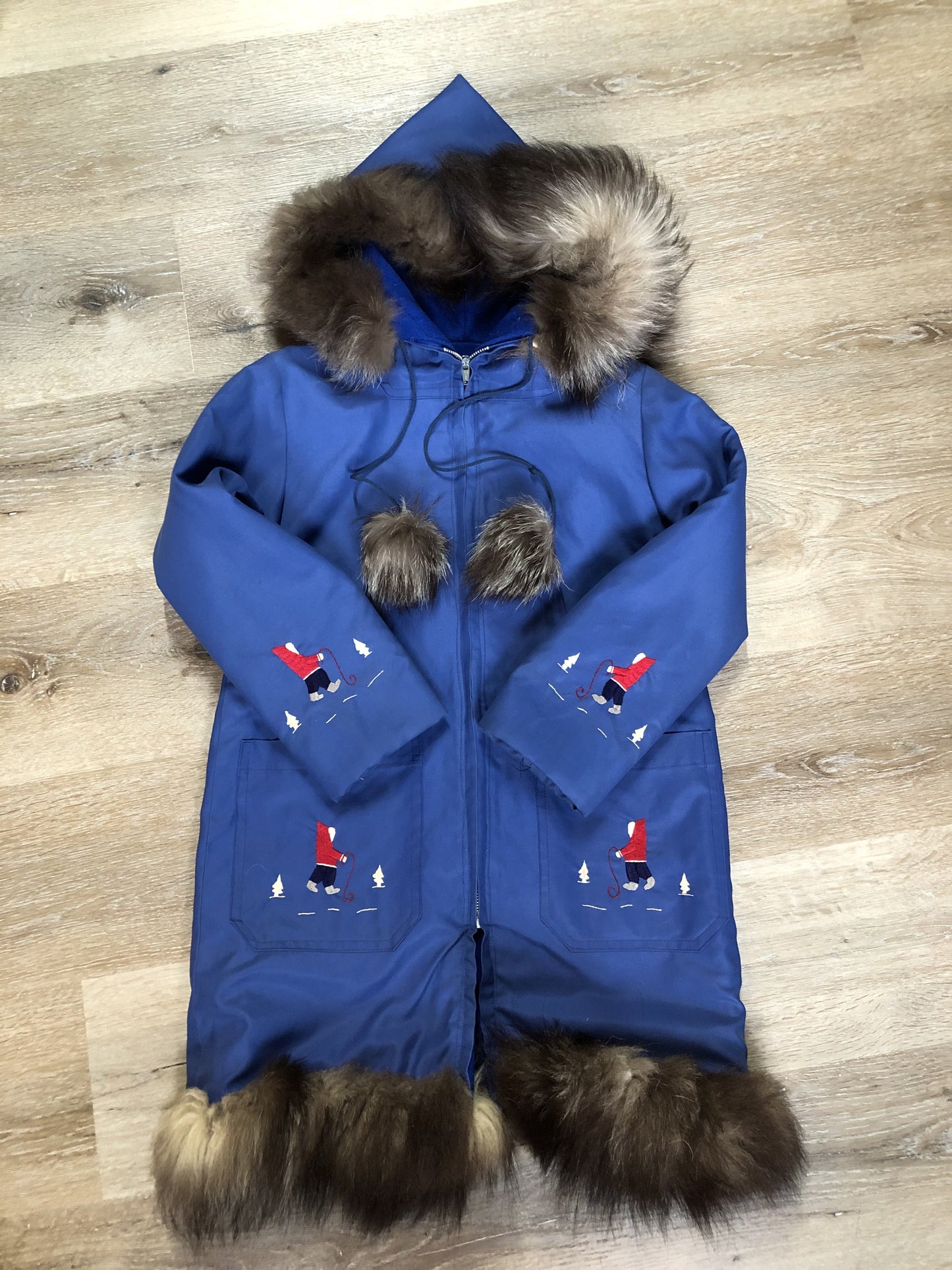 Kingspier Vintage - Children’s blue northern parka featuring a hood, fur trim and pom poms, zipper closure, wool lining, patch pockets, embroidered winter scenes along the front. Made in Canada.