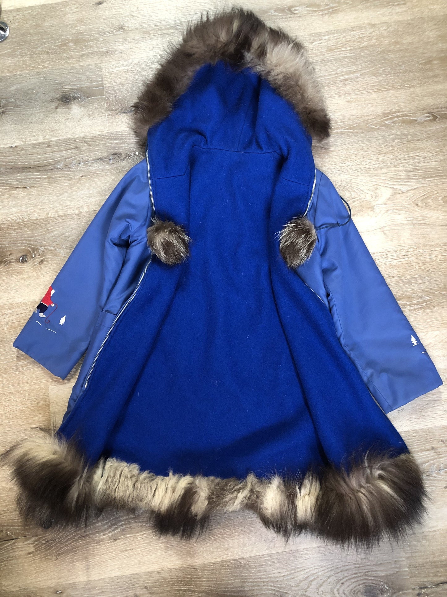 Kingspier Vintage - Children’s blue northern parka featuring a hood, fur trim and pom poms, zipper closure, wool lining, patch pockets, embroidered winter scenes along the front. Made in Canada.