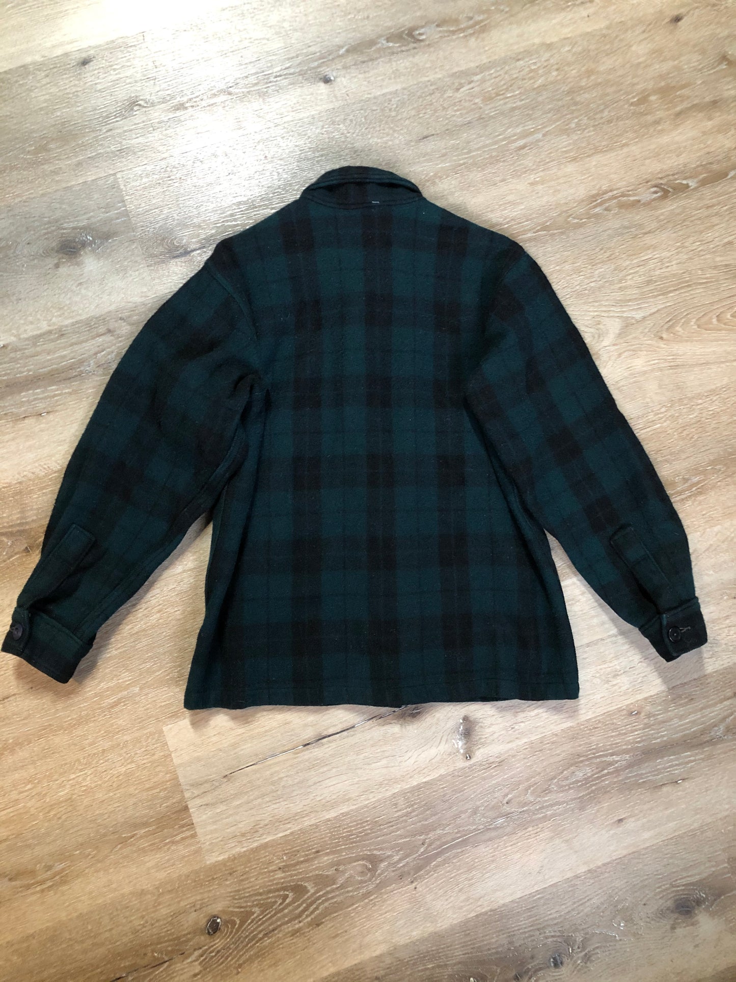 Kingspier Vintage - Woolrich dark green plaid wool lumberjack shirt with button closures and two flap pockets on the chest.