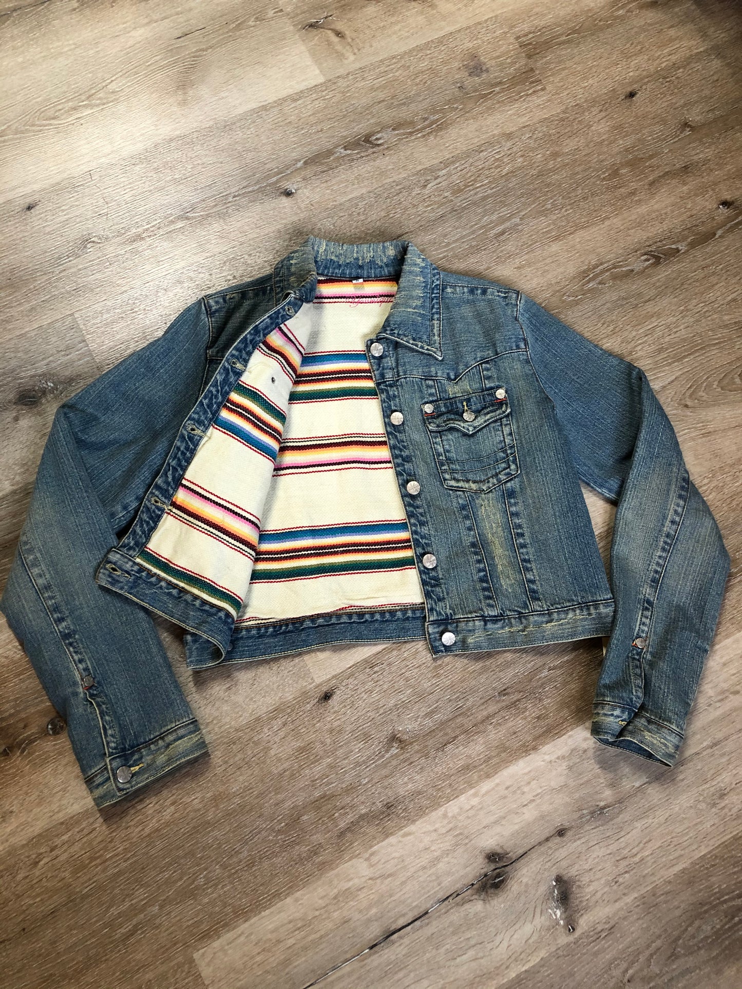 Kingspier Vintage - Younique denim jacket in a distressed light wash with colourful striped wool blend lining, button closures and two flap pockets. Size large, fits more like a medium.