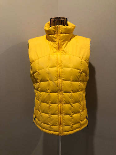 Kingspier Vintage - Columbia down filled puffer vest in yellow with zipper closure, vertical zip pockets, inside pocket and drawstring at the bottom hem. Size medium.