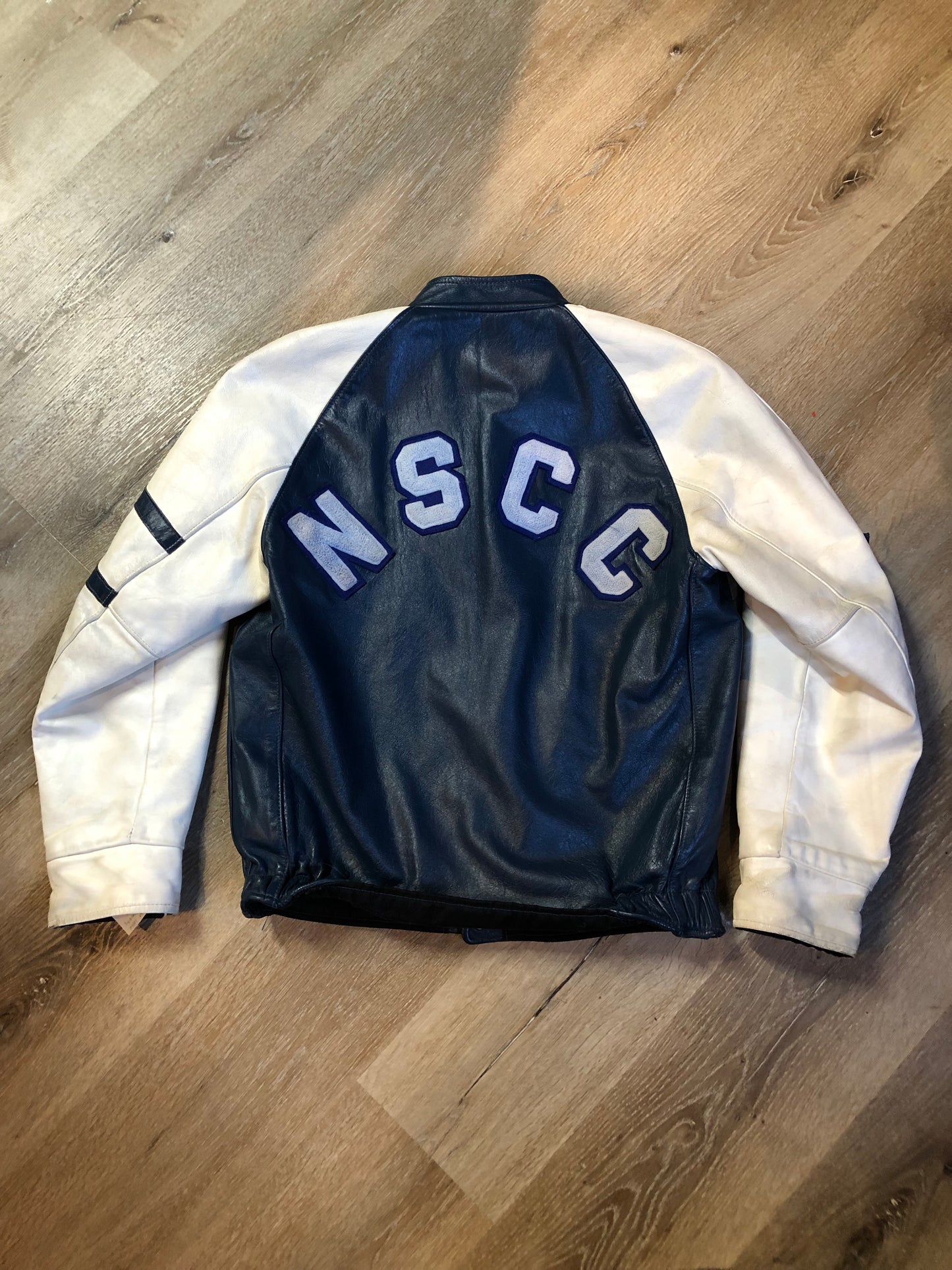 Kingspier Vintage - Vintage NSCC Pictou Campus leather varsity jacket in blue and white with snap closures, slash pockets, “Pictou Campus” embroidered on the chest, “NSCC” Embroidered on the back and “Ron” monogram embroidered on the sleeve,