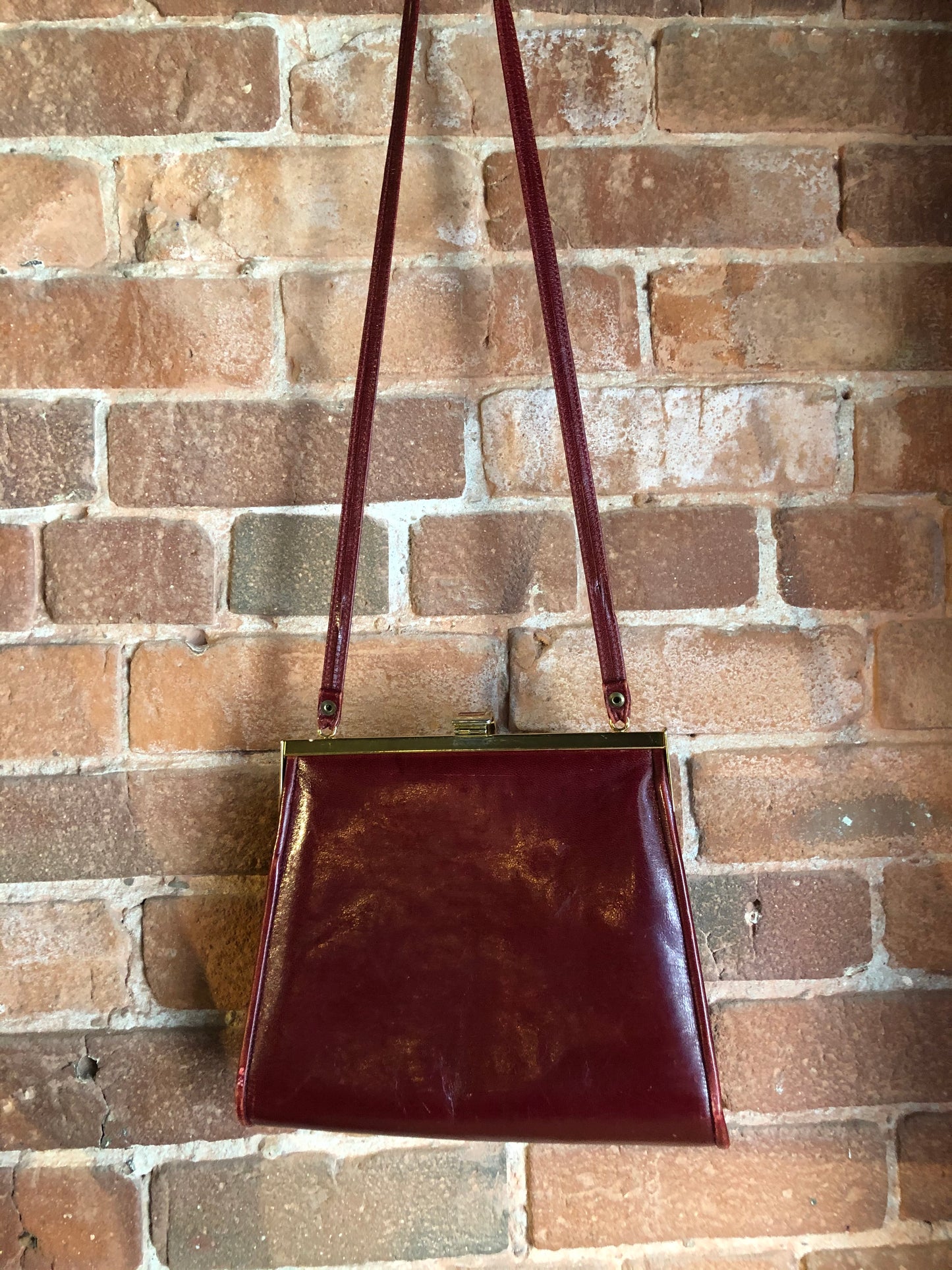 Kingspier Vintage - Deep red leather handbag circa 1950’s with brass metal details and clasp.