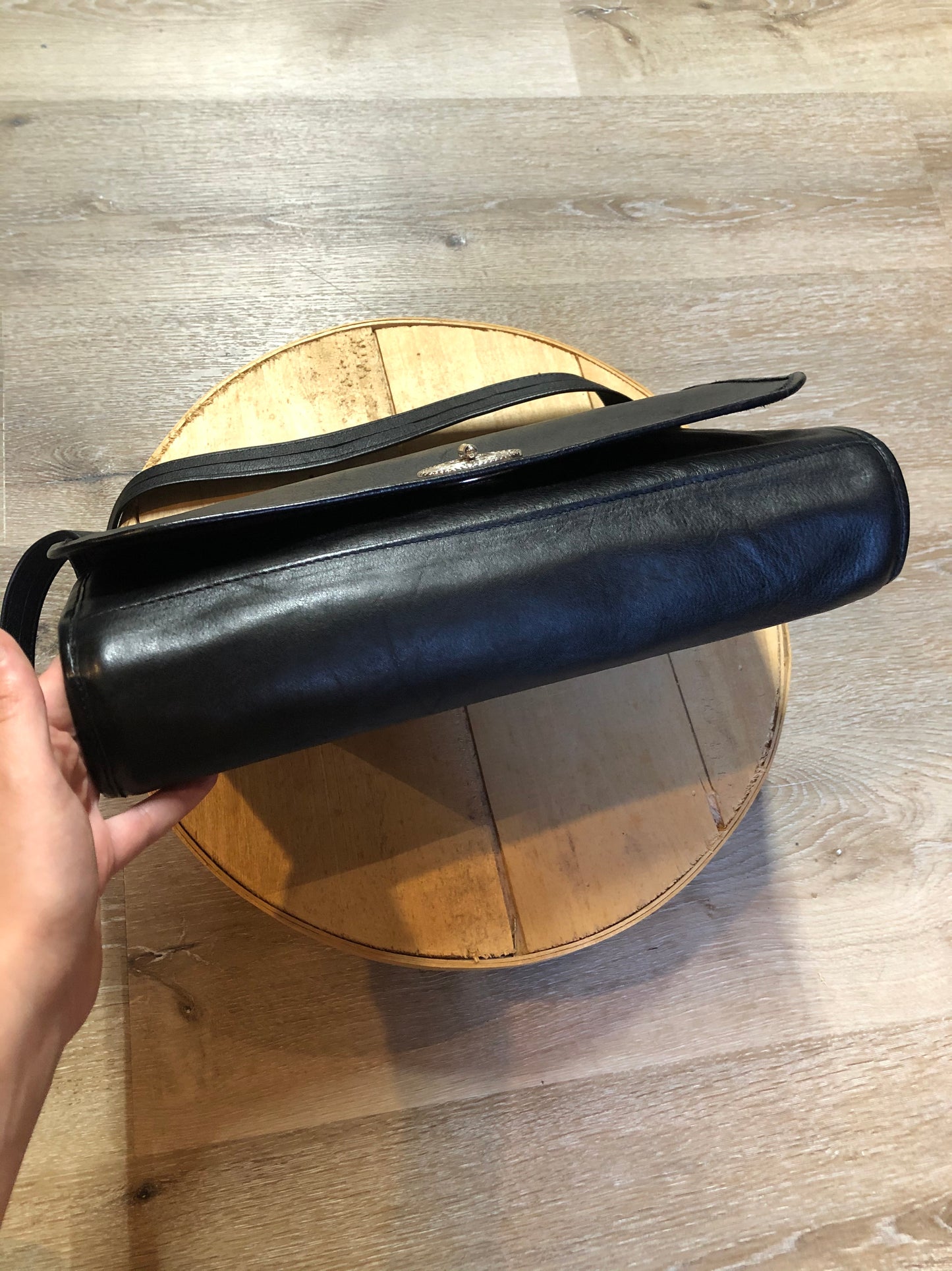 Kingspier Vintage - Black leather satchel with ornate front closure, lined in maroon coloured leather and features many inside pockets.