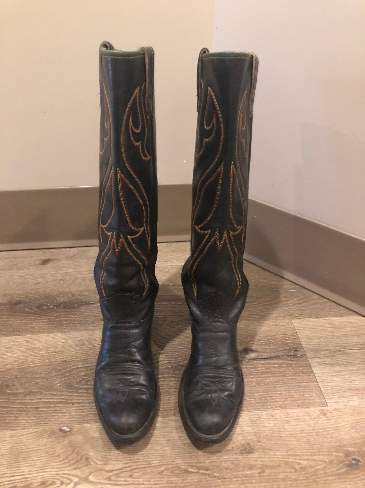 Stewart Co knee high leather cowboy boots in black with rainbow stitching. Leather lined with leather soles. Made in USA Size 7.5W US, 38 EUR