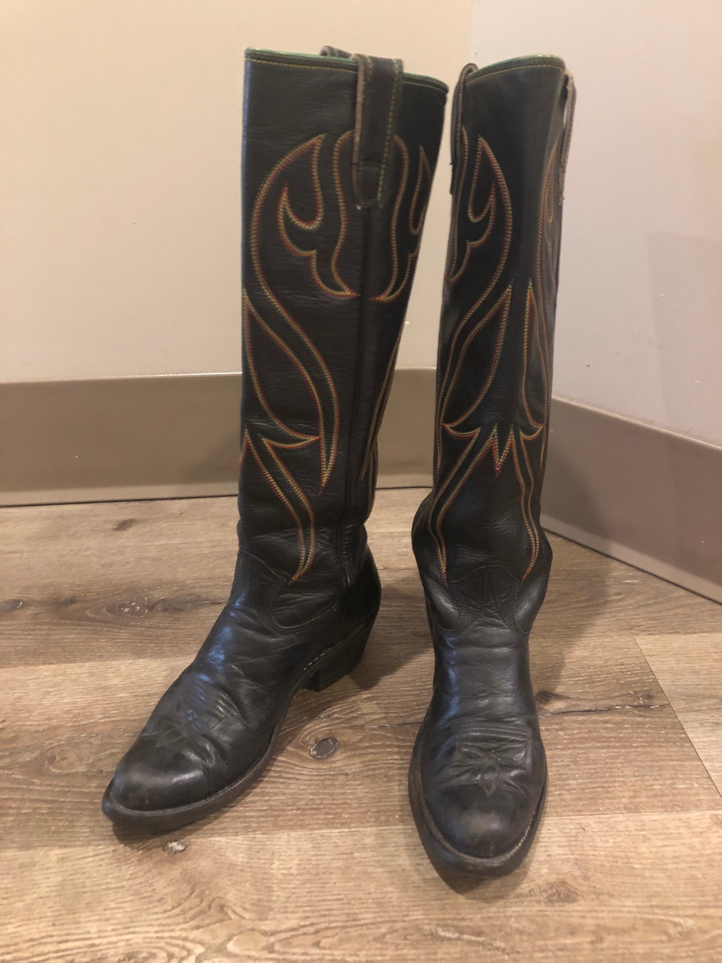 Stewart Co knee high leather cowboy boots in black with rainbow stitching. Leather lined with leather soles. Made in USA Size 7.5W US, 38 EUR