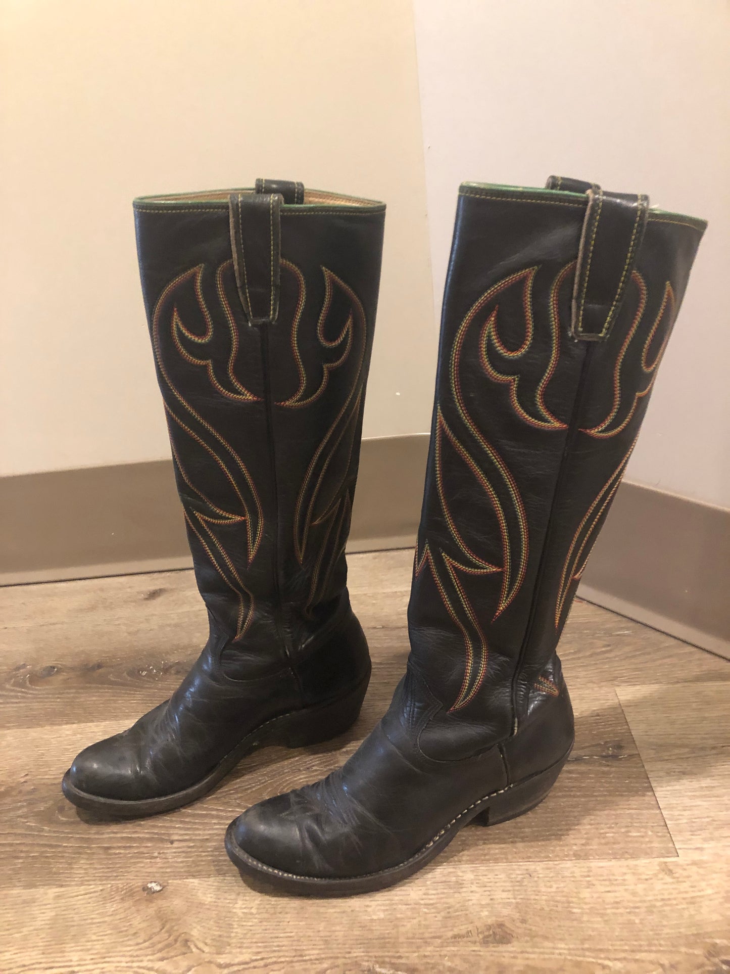 Stewart Co knee high leather cowboy boots in black with rainbow stitching. Leather lined with leather soles. Made in USA Size 7.5W US, 38 EUR