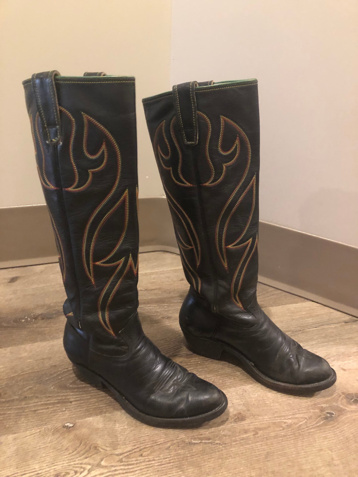 Stewart Co knee high leather cowboy boots in black with rainbow stitching. Leather lined with leather soles. Made in USA Size 7.5W US, 38 EUR