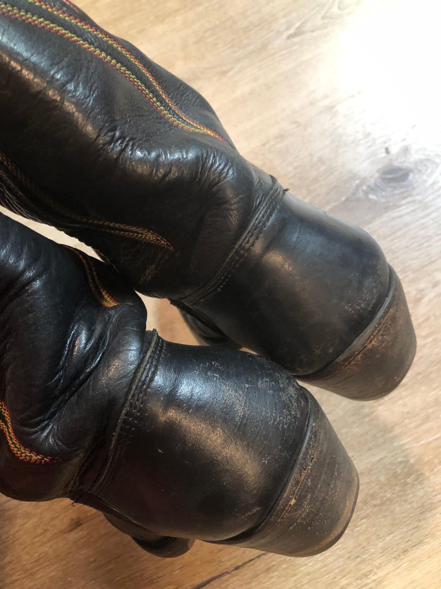 Stewart Co knee high leather cowboy boots in black with rainbow stitching. Leather lined with leather soles. Made in USA Size 7.5W US, 38 EUR