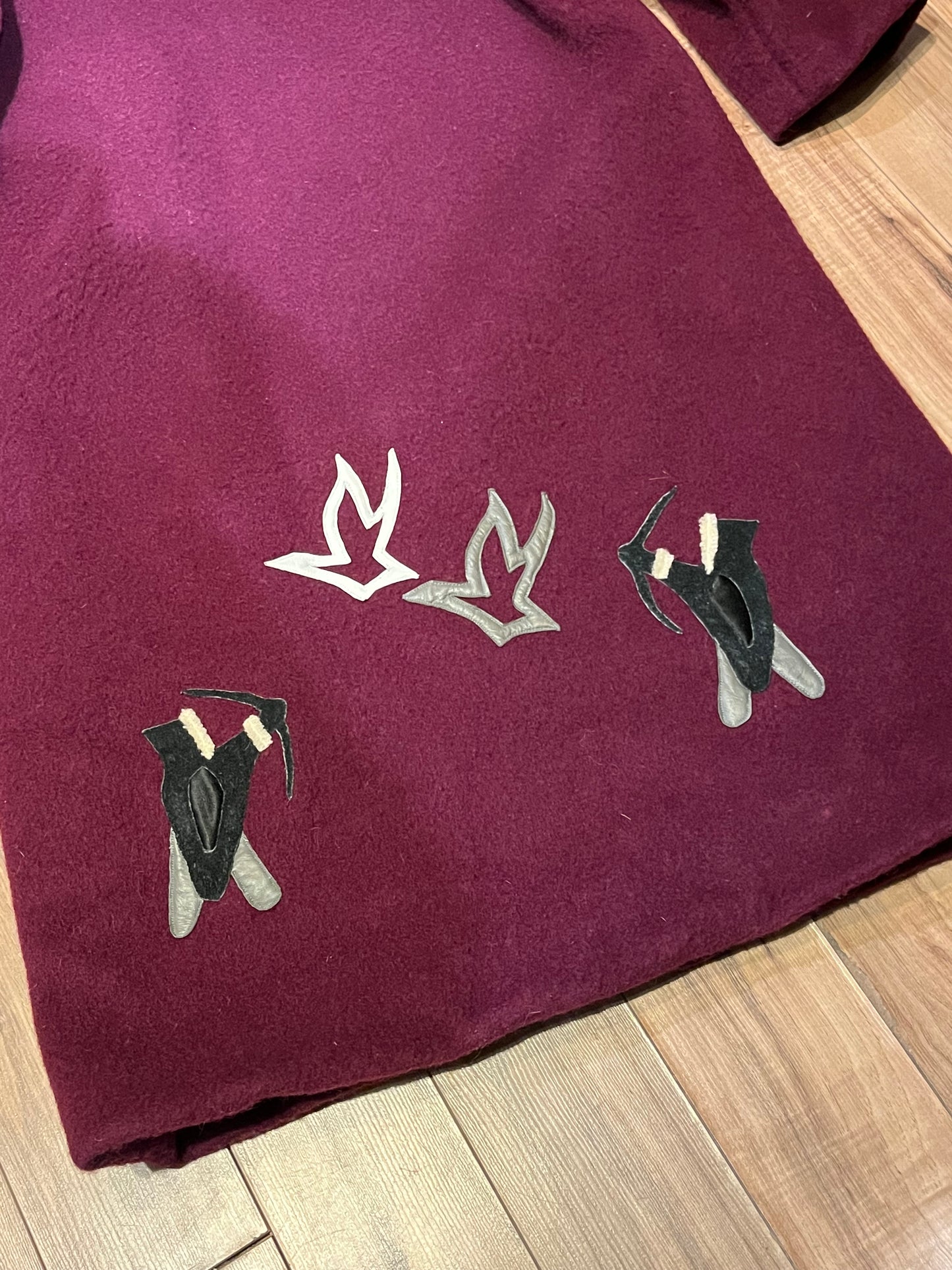 Vintage 100% wool long northern parka with zipper closure, front pockets, fur trimmed hood and suede applique in a bow and arrow hunting motif.
Indigenous made
Chest 46”