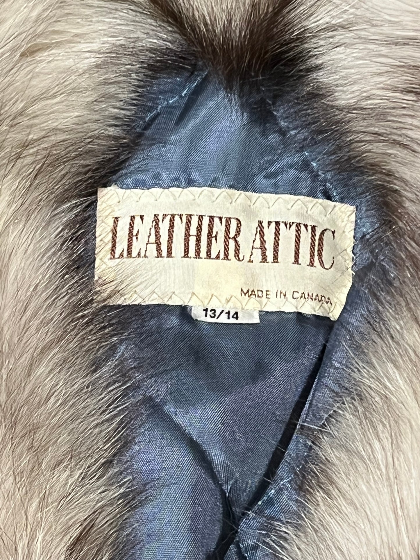 Vintage Leather Attic long blue/grey suede coat with white fur collar, belt, two front pockets, button closures and a quilted lining.
Made in Canada, Size 13/14