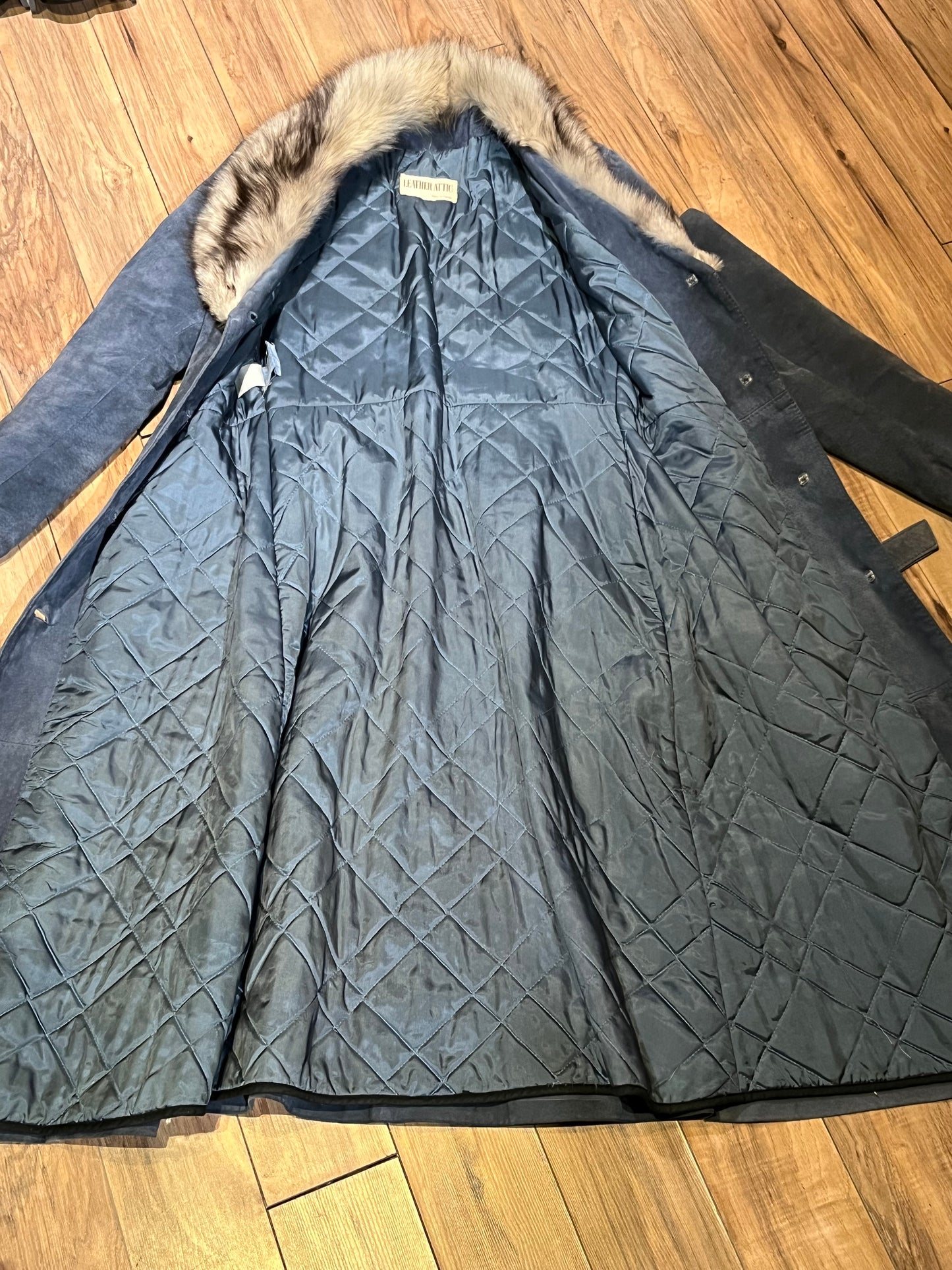 Vintage Leather Attic long blue/grey suede coat with white fur collar, belt, two front pockets, button closures and a quilted lining.
Made in Canada, Size 13/14