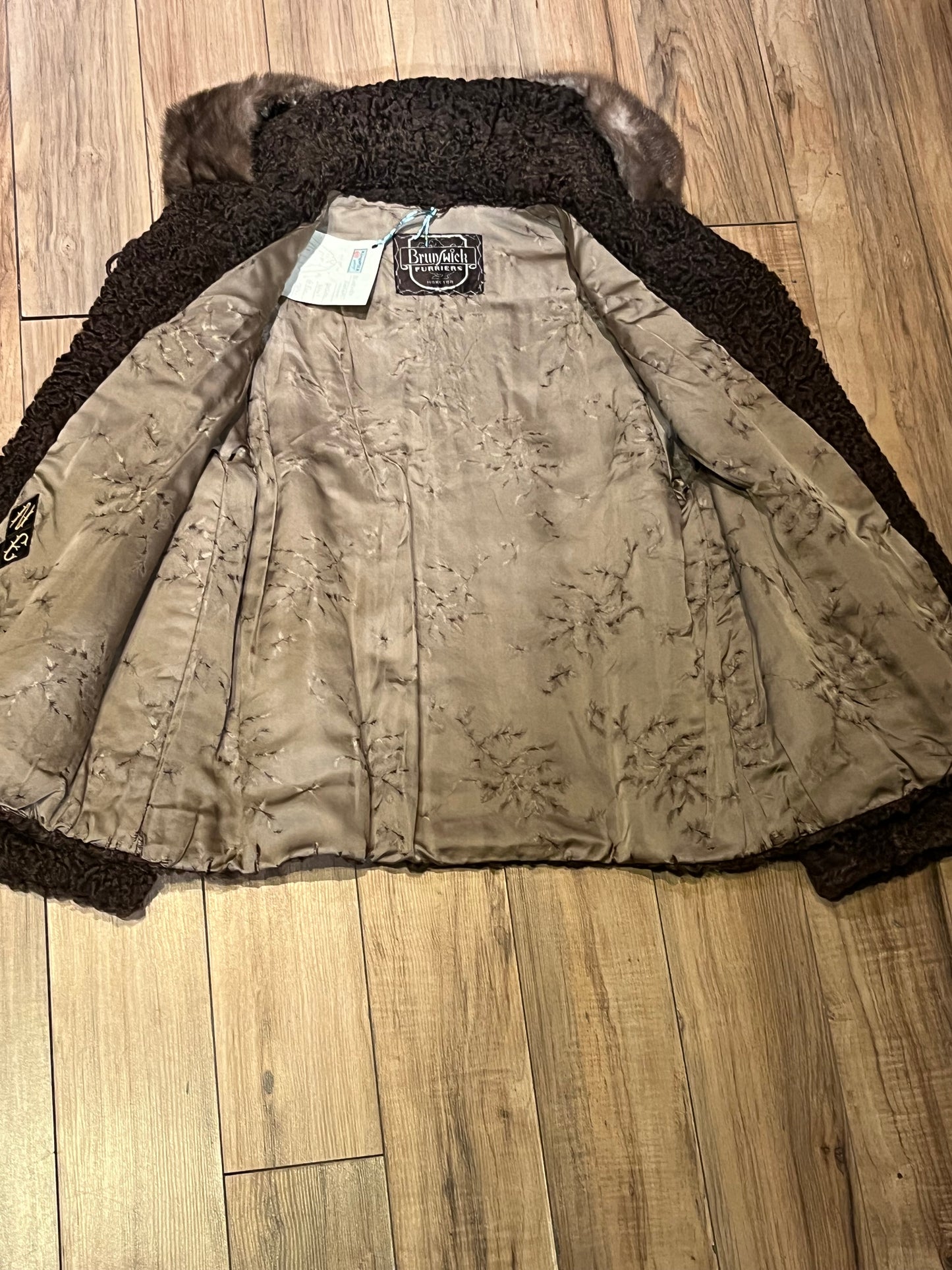 Vintage Brunswick Furriers brown persian lamb jacket with fur collar, two front pockets, flower decorated button closures and a “N.G.S” monogram on the inside lining.
Made in Canada, Chest 38”