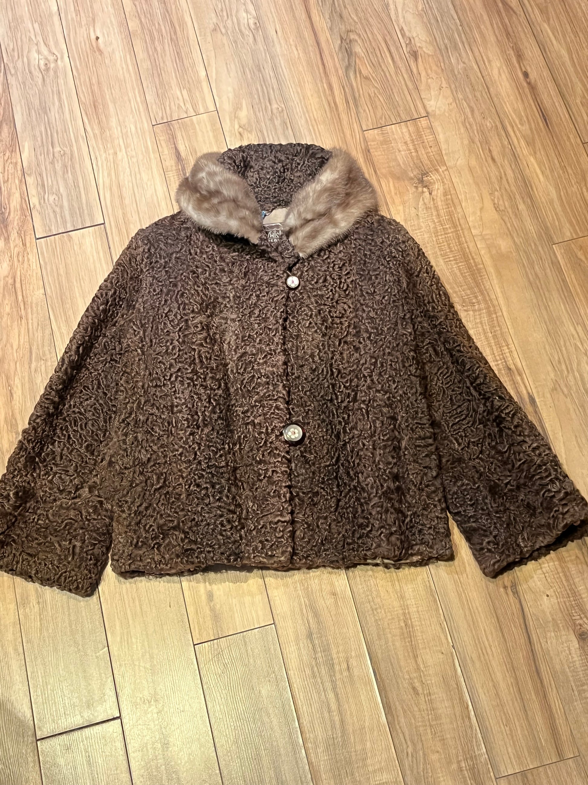 Vintage Brunswick Furriers brown persian lamb jacket with fur collar, two front pockets, flower decorated button closures and a “N.G.S” monogram on the inside lining.
Made in Canada, Chest 38”