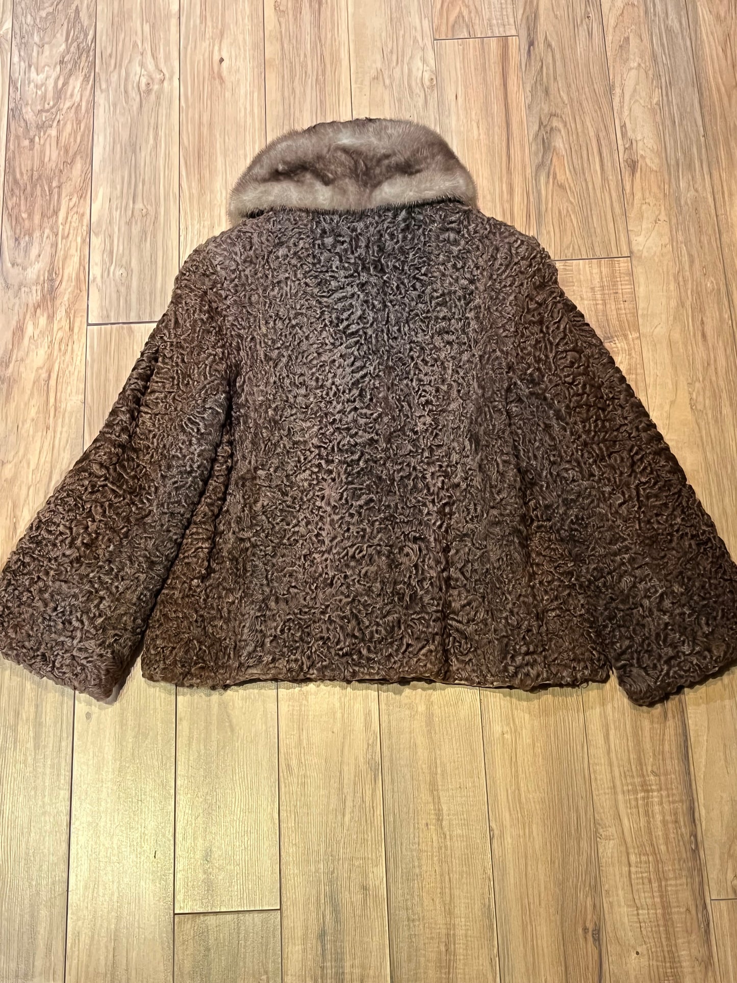 Vintage Brunswick Furriers brown persian lamb jacket with fur collar, two front pockets, flower decorated button closures and a “N.G.S” monogram on the inside lining.
Made in Canada, Chest 38”