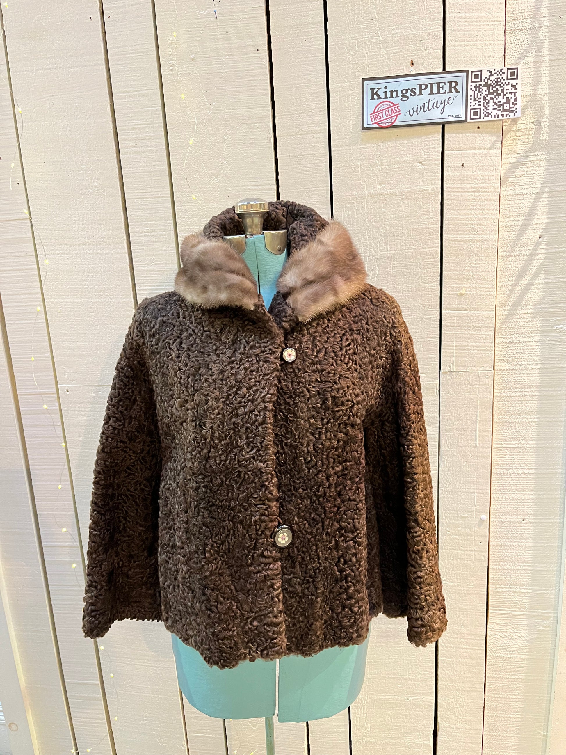 Vintage Brunswick Furriers brown persian lamb jacket with fur collar, two front pockets, flower decorated button closures and a “N.G.S” monogram on the inside lining.
Made in Canada, Chest 38”