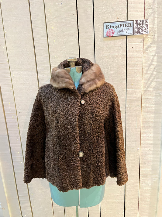Vintage Brunswick Furriers brown persian lamb jacket with fur collar, two front pockets, flower decorated button closures and a “N.G.S” monogram on the inside lining.
Made in Canada, Chest 38”