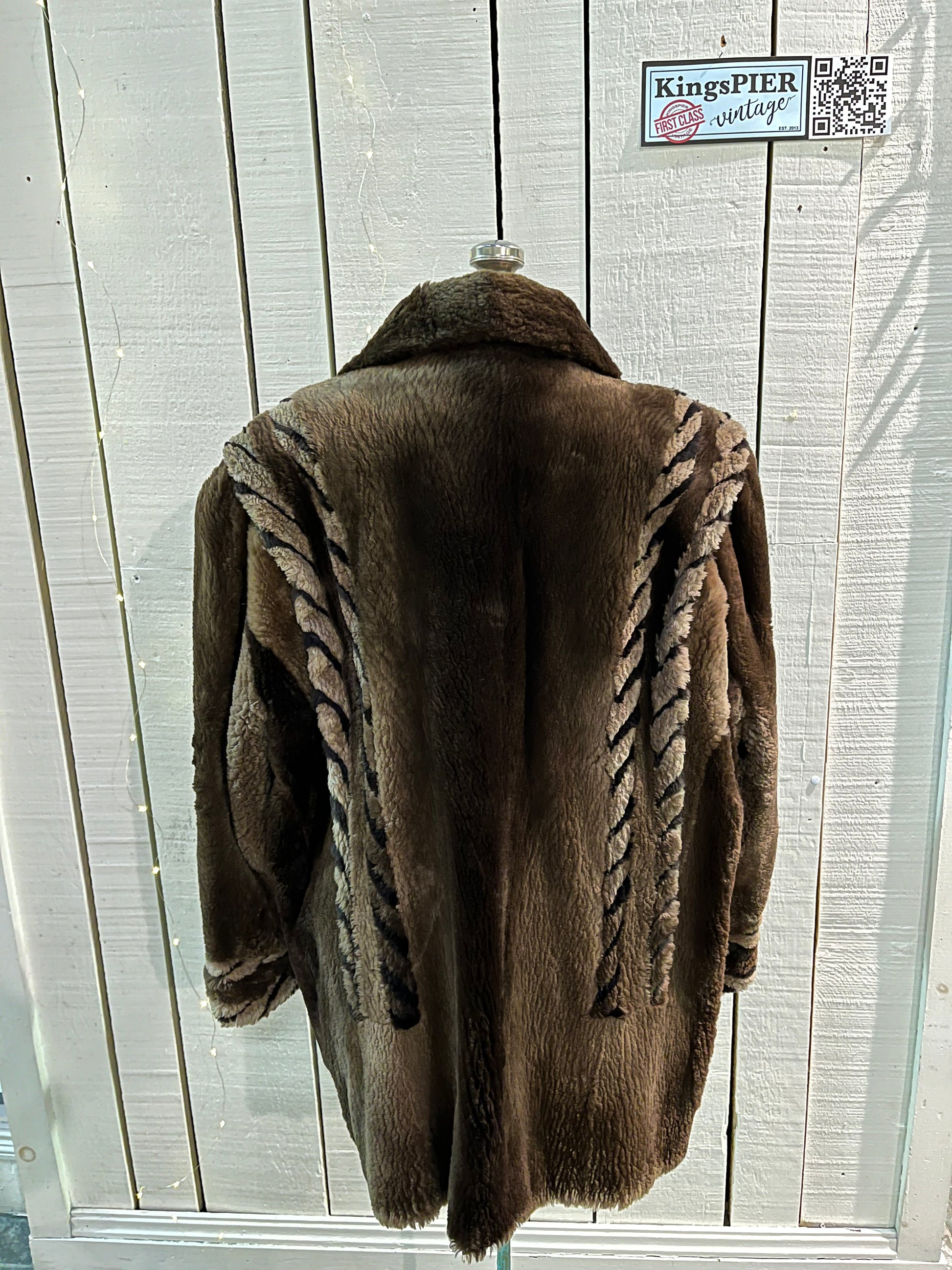 Vintage Eastern Furriers brown fur coat with hook and eye closures and two front pockets.
Although we can’t say for sure what the type of fur is, our educated guess is shorn beaver.
Made in Canada
