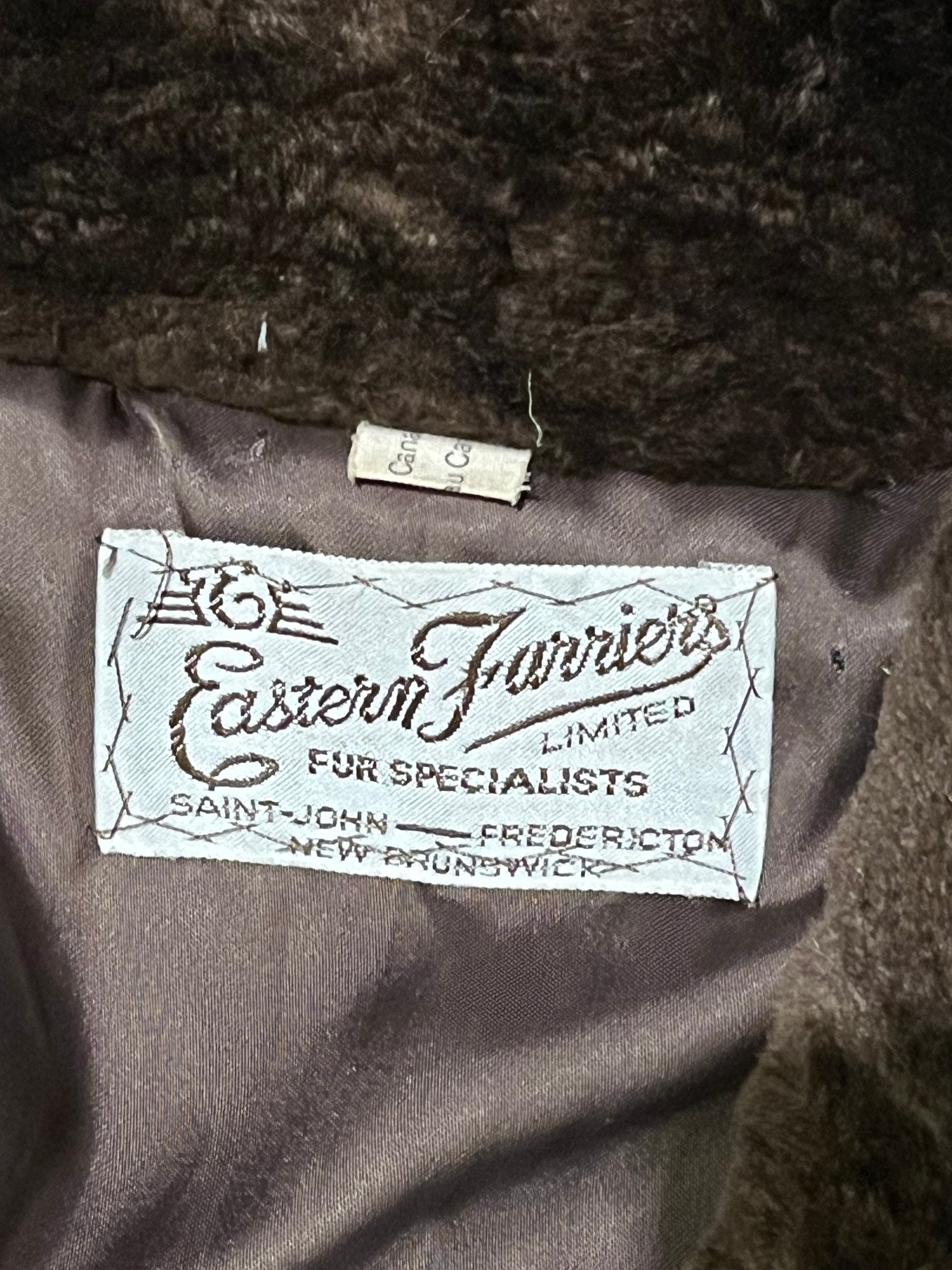 Vintage Eastern Furriers brown fur coat with hook and eye closures and two front pockets.
Although we can’t say for sure what the type of fur is, our educated guess is shorn beaver.
Made in Canada