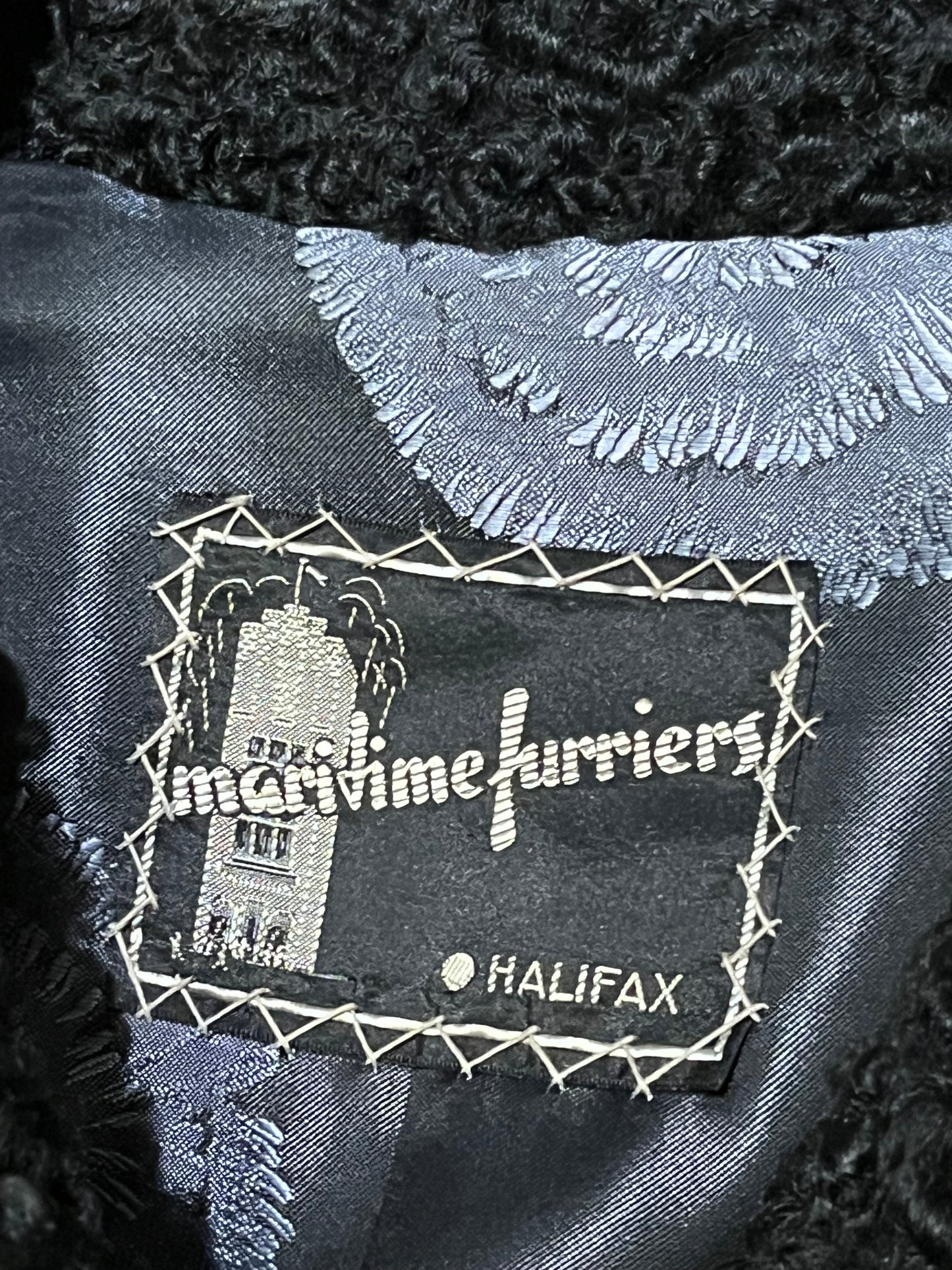 Vintage Maritime Furriers LTD black persian lamb fur coat with two front pockets, button closures and a satin lining with flower motif.
Chest 38”
