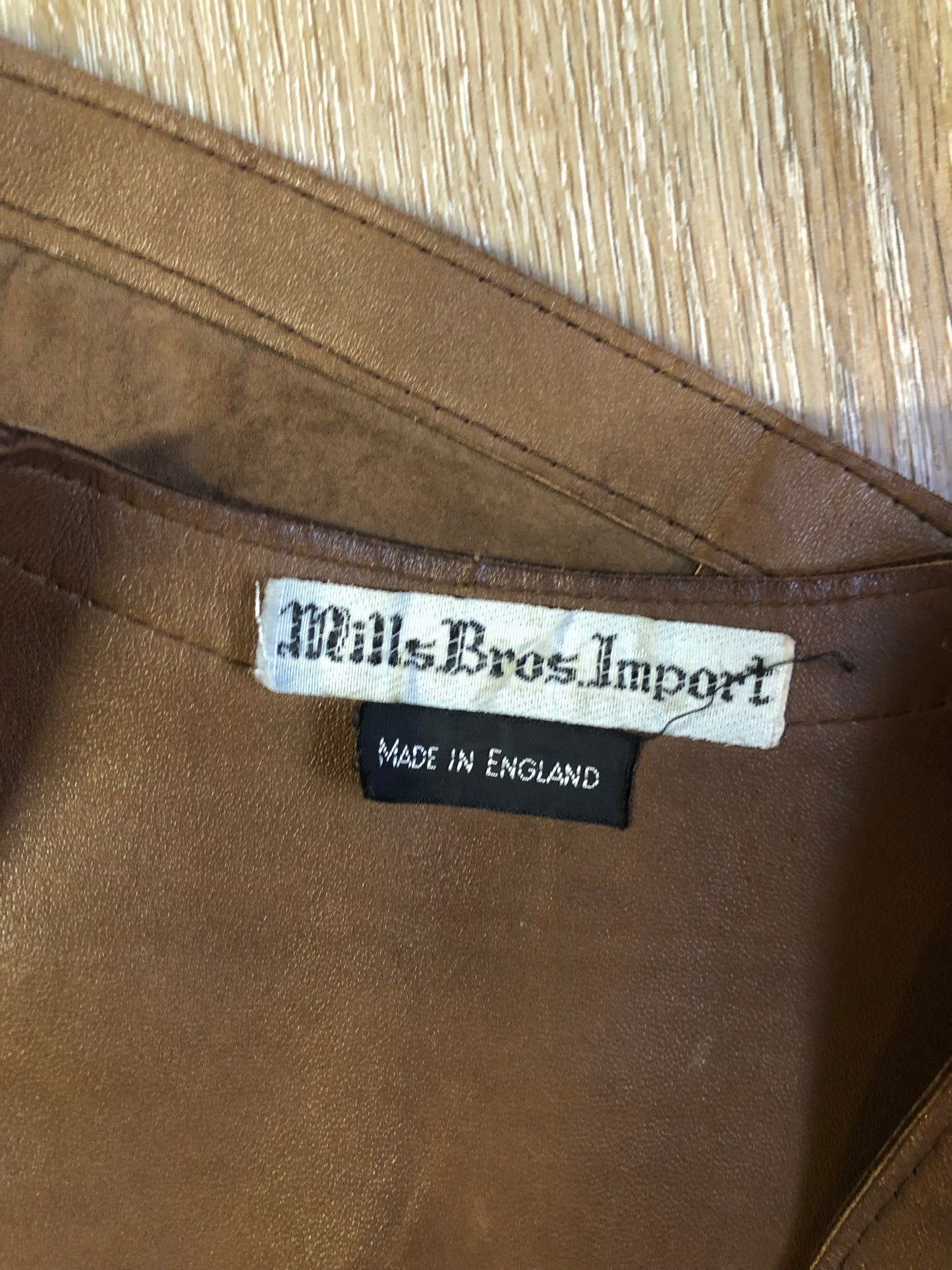 Vintage Mills Brothers deadstock 1960’s brown suede vest with large gold geometric front clasp, leather lining and trim and two patch pockets in the front. Suede and leather are buttery soft. Made in England - Kingspier Vintage