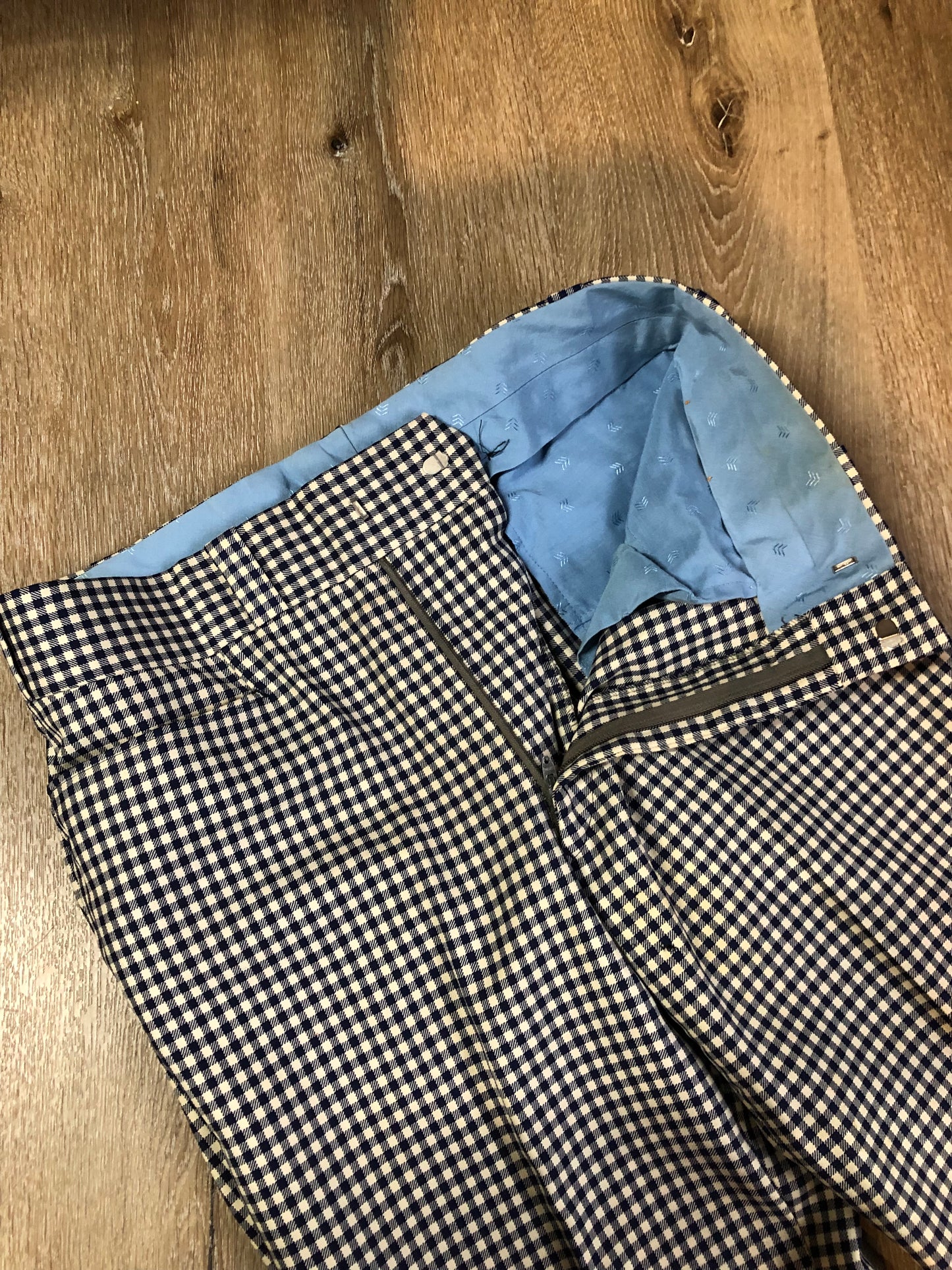 Vintage Saville Row two piece suit in navy and white gingham pattern is union made. Jacket is a two button, notch lapel with two flap pockets in the front, one breast pocket and two inside pockets. Trousers feature a mid rise, wide leg, pressed crease and two front and back pockets.38”x28.5” - Kingspier Vintage