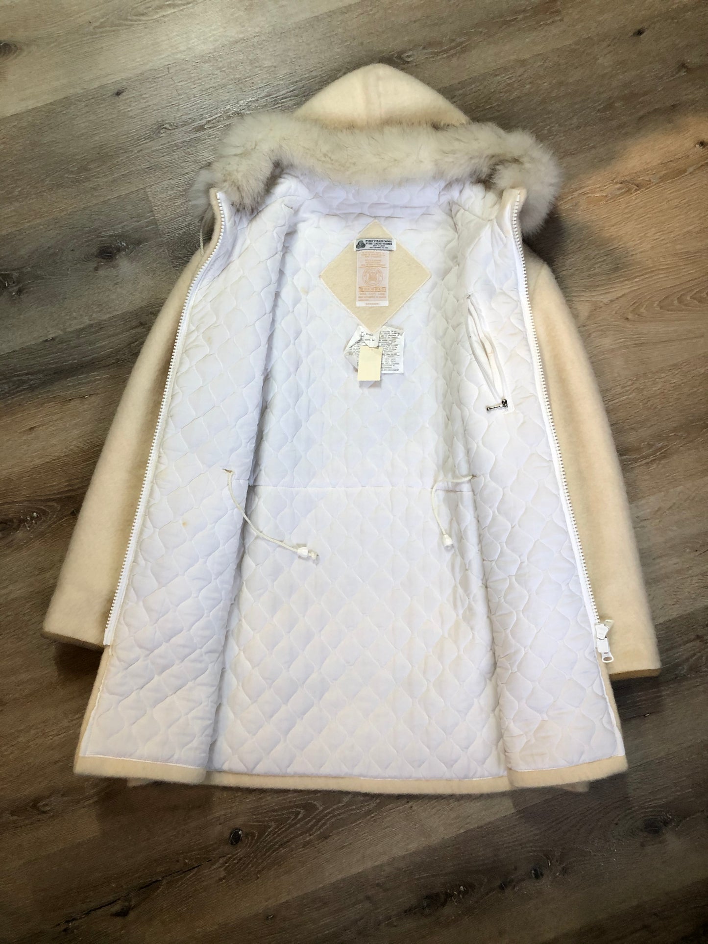 Kingspier Vintage - Hudson’s Bay Company white pure virgin wool northern parka featuring a hood with fox fur trim, zipper closure, quilted lining, inside drawstring, slash pockets, hidden knit cuffs and tree a nd igloo design suede appliqué on the front and back. Made in Canada. Size 14/ large.