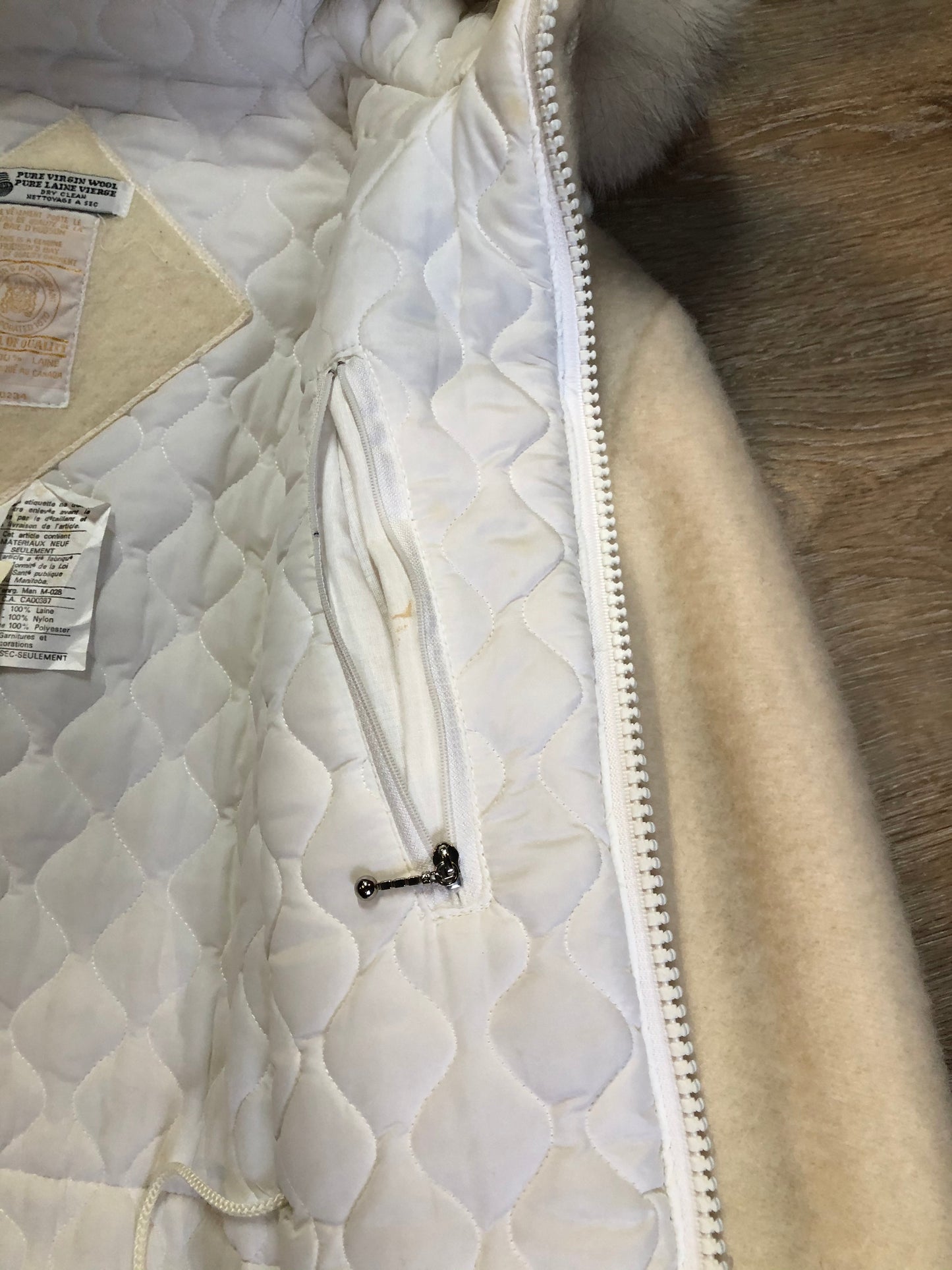 Kingspier Vintage - Hudson’s Bay Company white pure virgin wool northern parka featuring a hood with fox fur trim, zipper closure, quilted lining, inside drawstring, slash pockets, hidden knit cuffs and tree a nd igloo design suede appliqué on the front and back. Made in Canada. Size 14/ large.